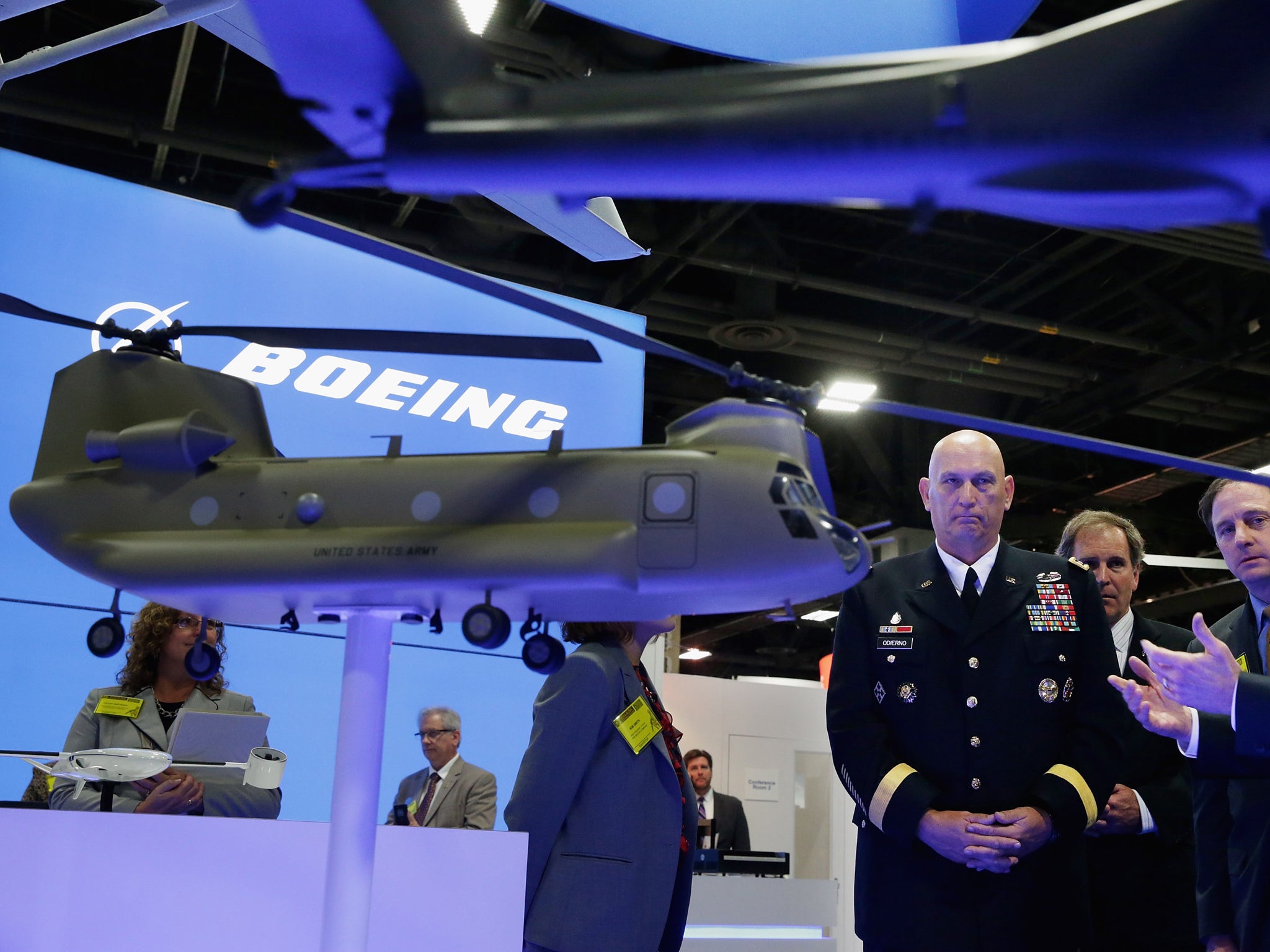 U.S. Army Chief of Staff Gen. Raymond Odierno talks with Boeing Army Systems Vice President Jamey Moran and other executives in their booth during the Association of the United States Army annual meeting and exposition at the Washington Convention Center