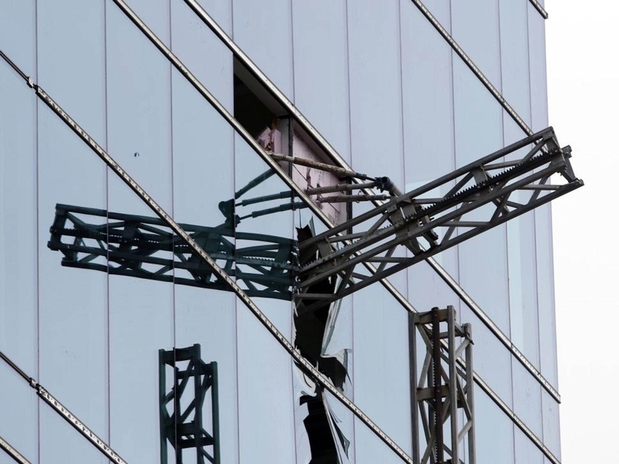 A section of scaffolding protrudes from a shattered window at the scene of a construction accident that killed three people and sent another to a hospital, Monday, March 23, 2015, in Raleigh, N.C. A scaffolding holding at least three workers fell and cra