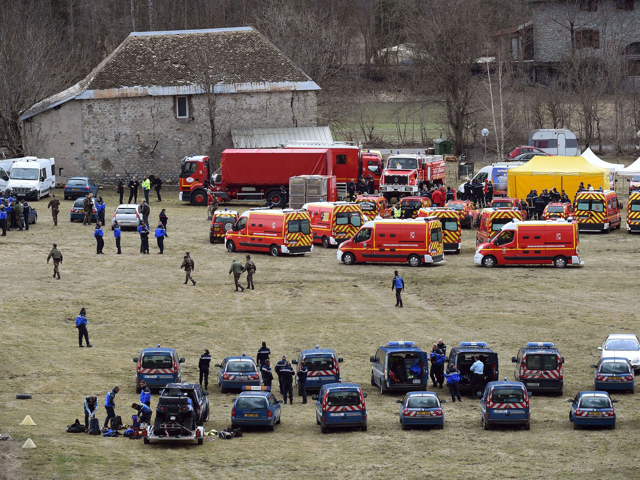 French emergency services workers (back) and members of the French gendarmerie gather in Seyne, south-eastern France, near the site where a Germanwings Airbus A320 crashed in the French Alps