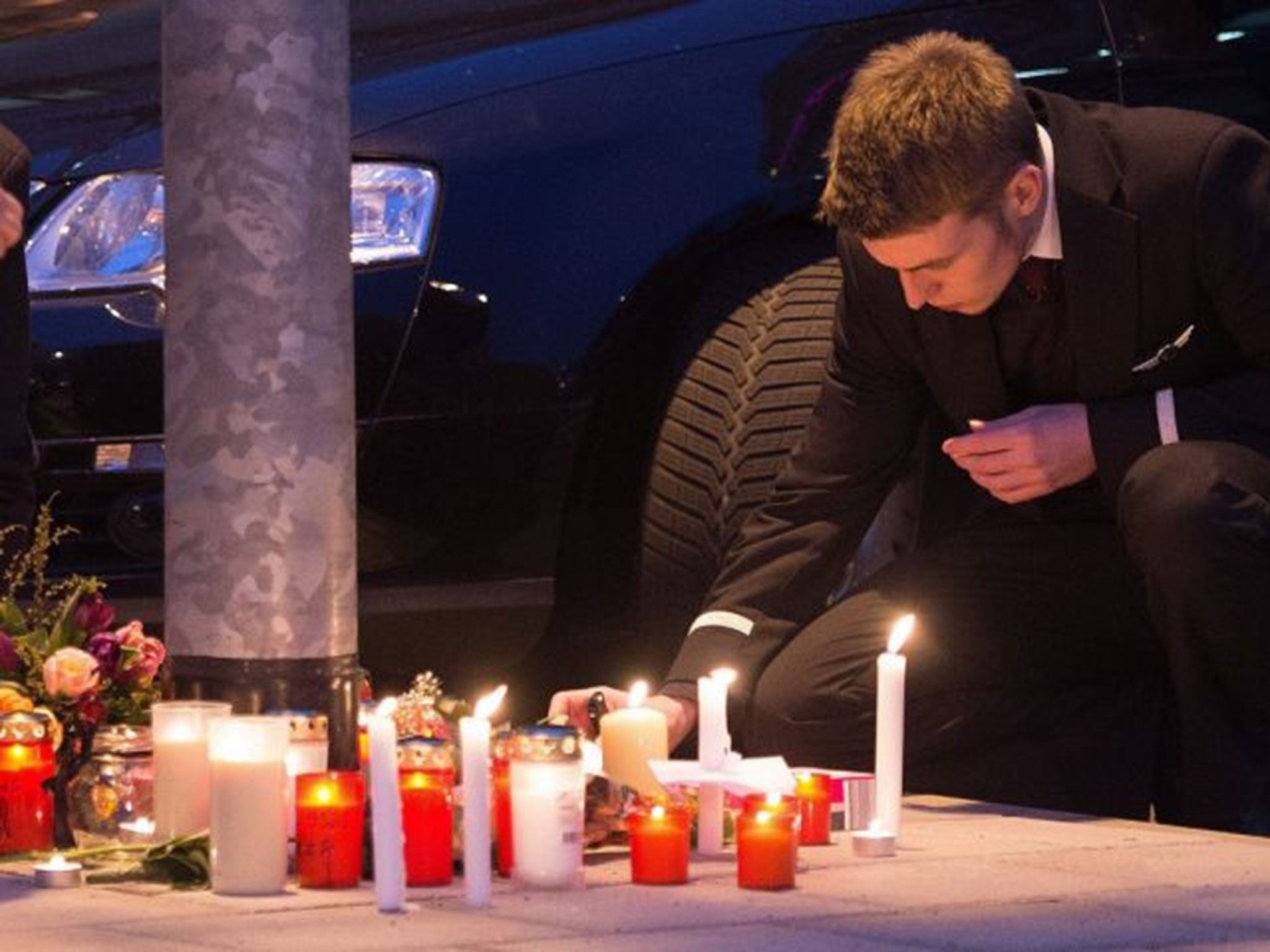 An employee of Germanwings and Lufthansa lay flowers and candles outside the headquarters of Germanwings in Cologne, Germany, 24 March 2015. (Image: EPA/Marius Becker)