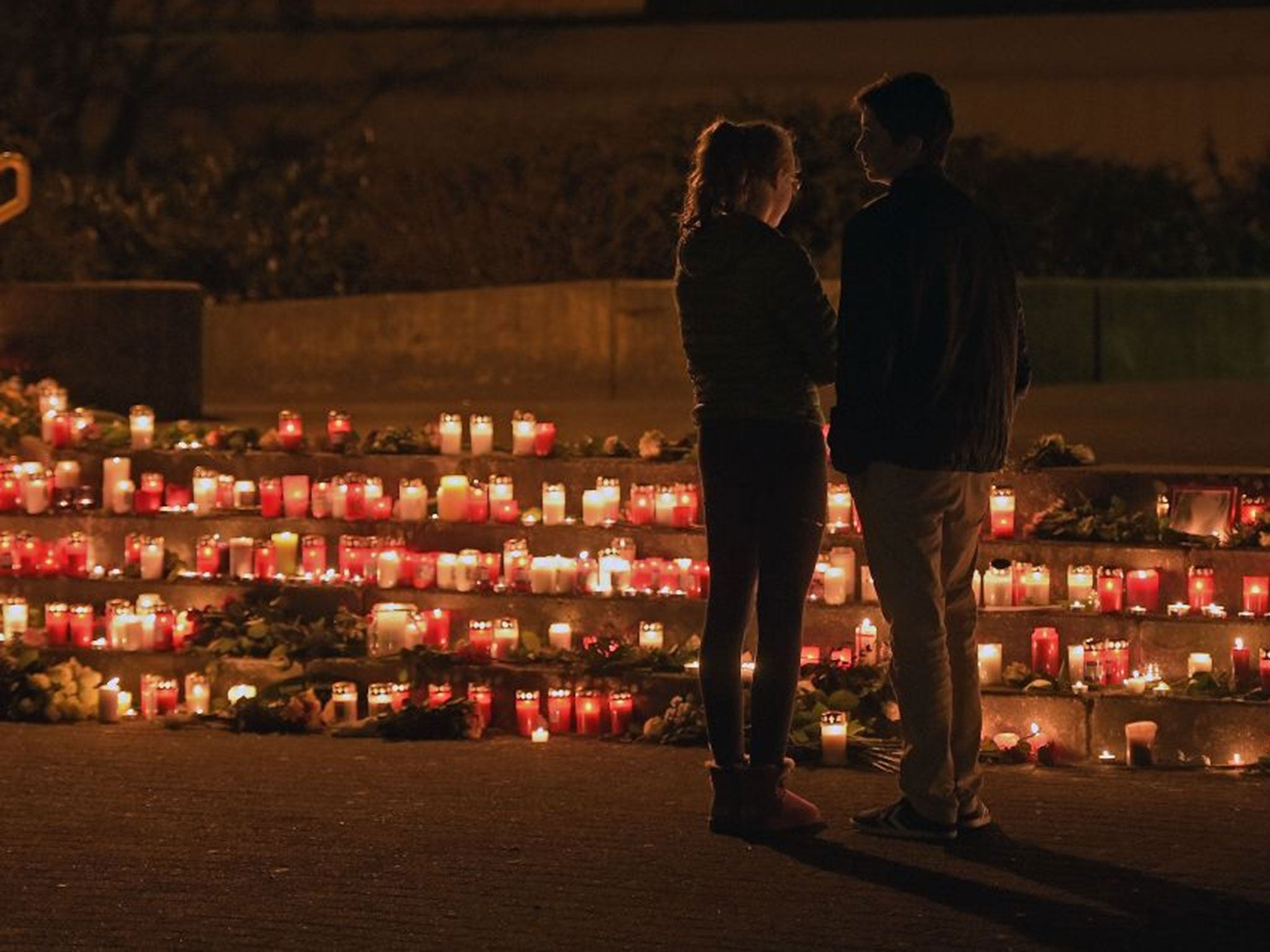 Students stand in front of candles in front of the Joseph-Koenig Gymnasium.