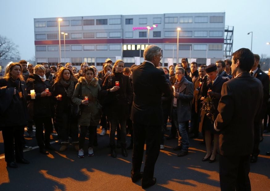 Thomas Winkelmann, Managing Director of Germanwings, speaks to employees next to Chief Pilot of Germanwings Stefan Kenan Scheib (R) as they prepare to place lit candles outside Germanwings headquarters at Cologne Bonn. (Image: REUTERS/Wolfgang Rattay)