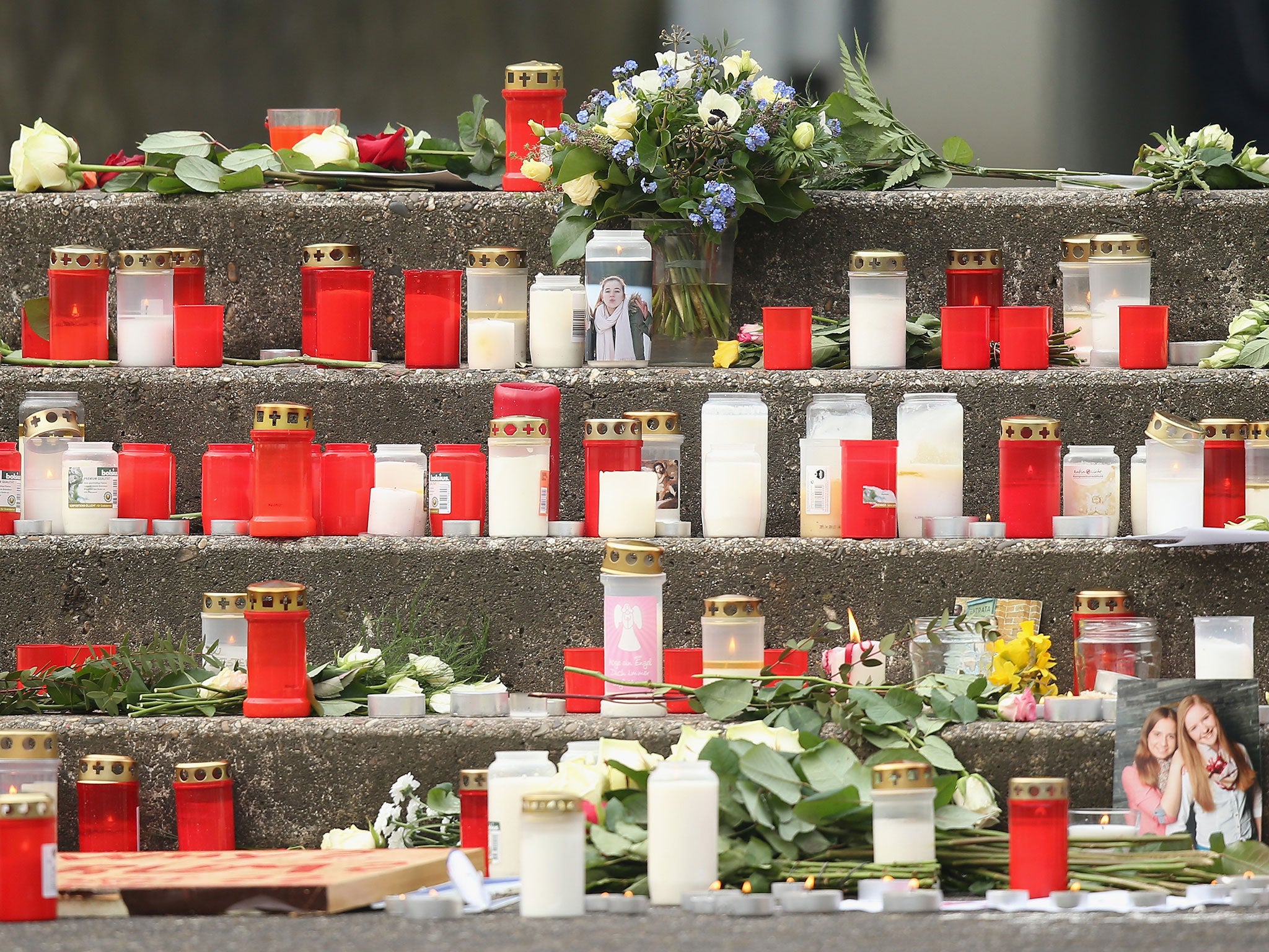 Photograph of victims, flowers and candles stand outside the Joseph-Koenig-Gymnasium