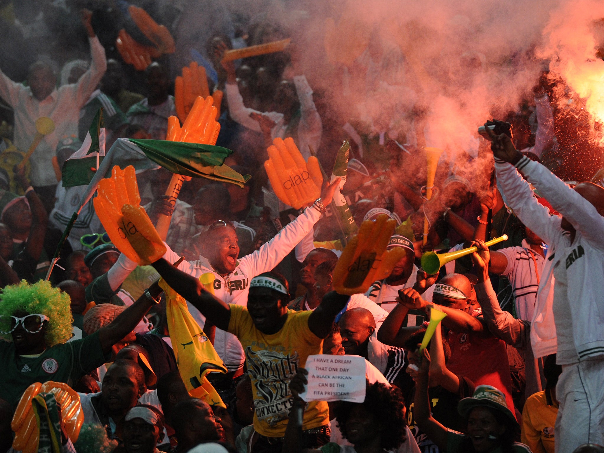 Nigerian football fans show their passion by setting off flares and blowing vuvuzelas