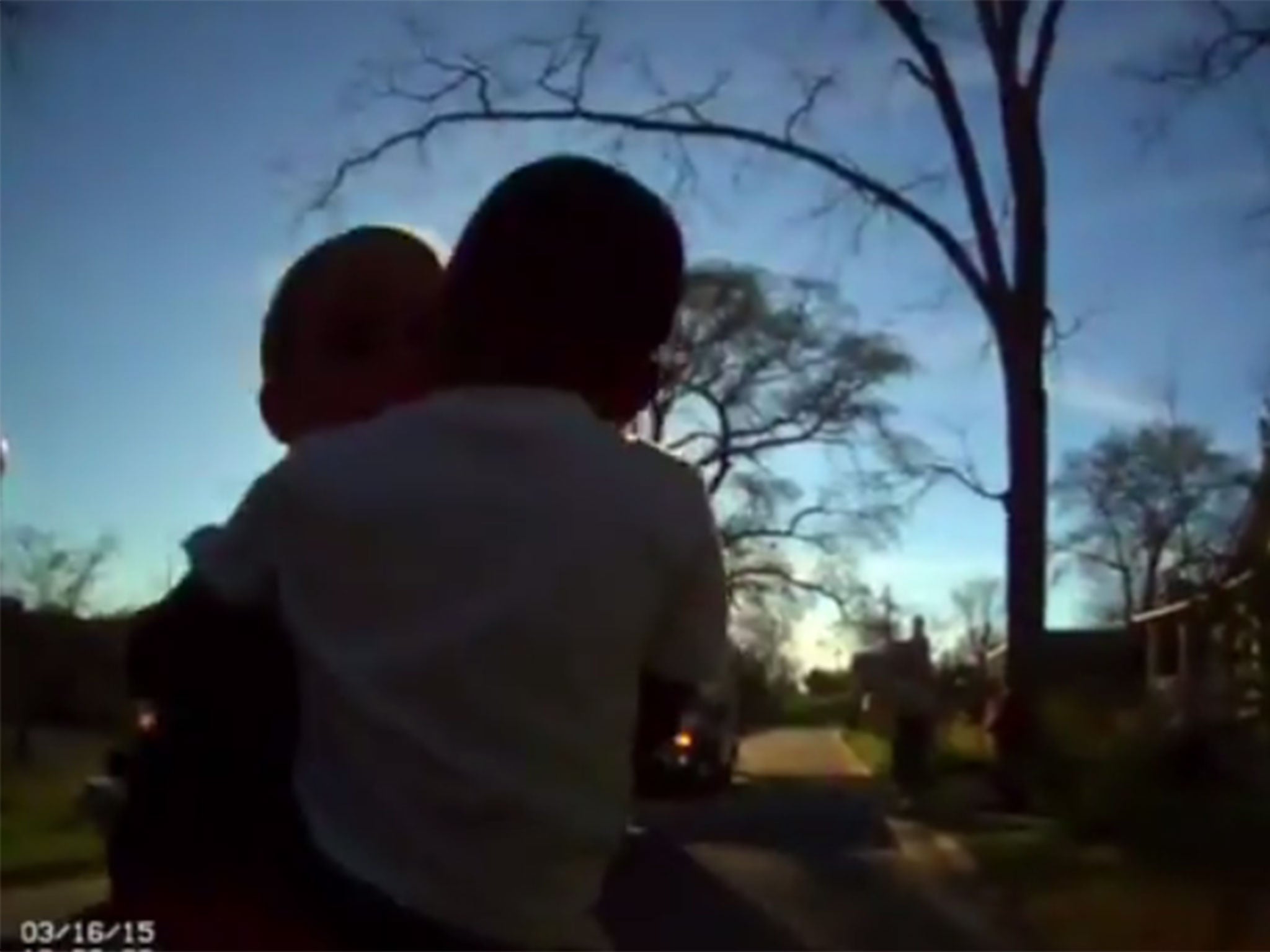 Officer Hudson carrying the boy from the burning house