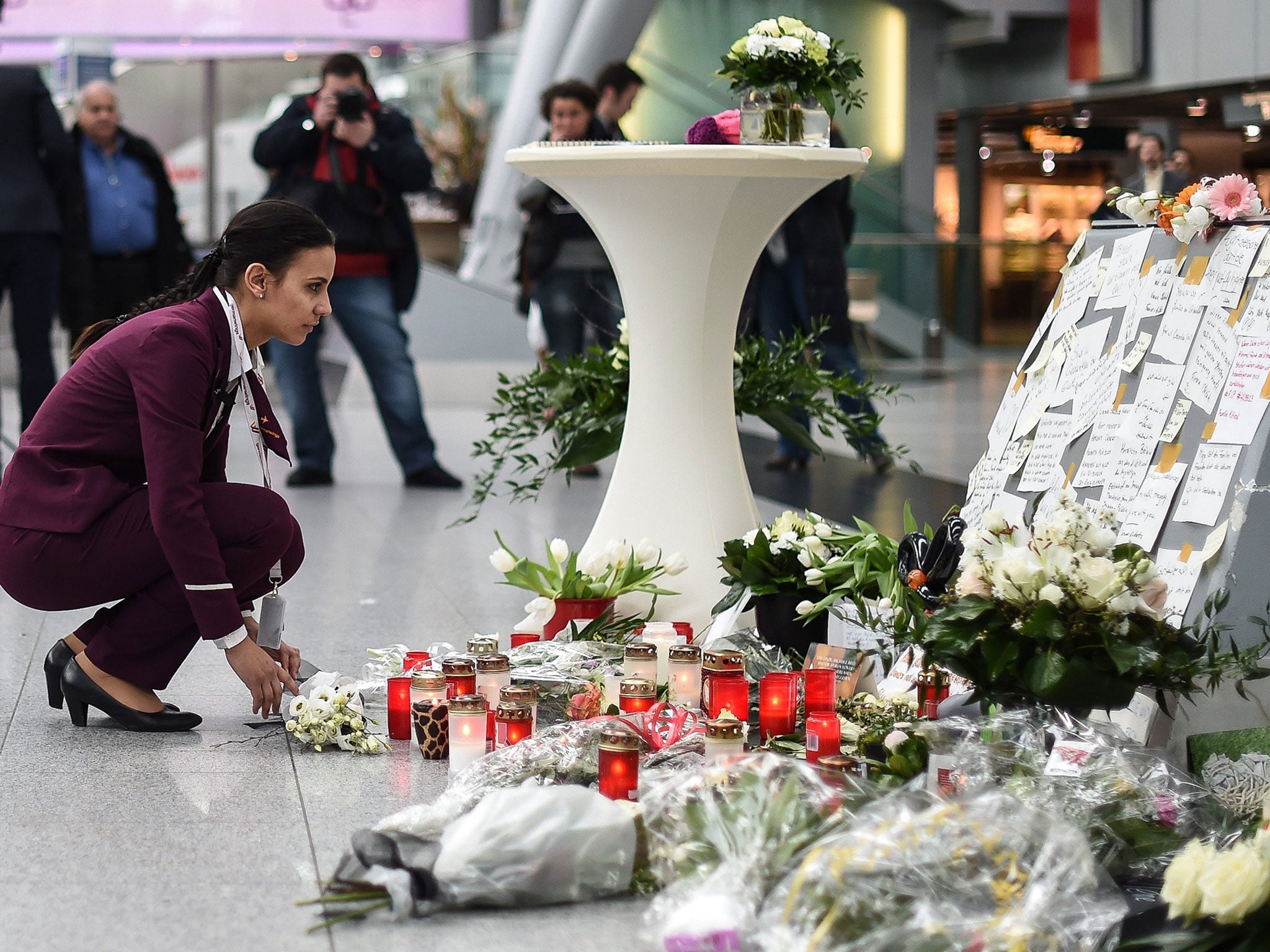 A Germanwings employee places flowers in commemoration of the victims of the Germanwings plane crash in the French Alps, at the airport in Duesseldorf, Germany
