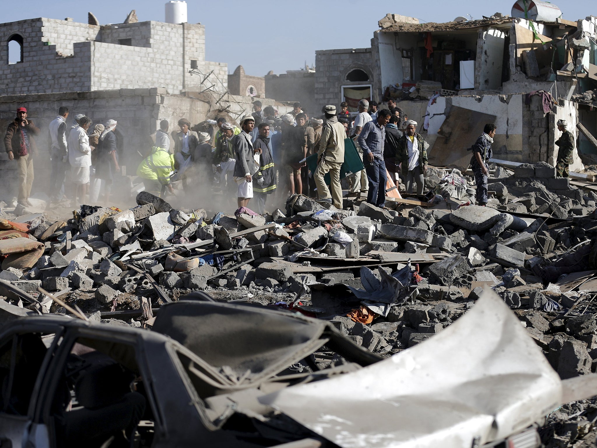 Civil defence workers and people search for survivors under the rubble of houses destroyed by an air strike near Sanaa Airport