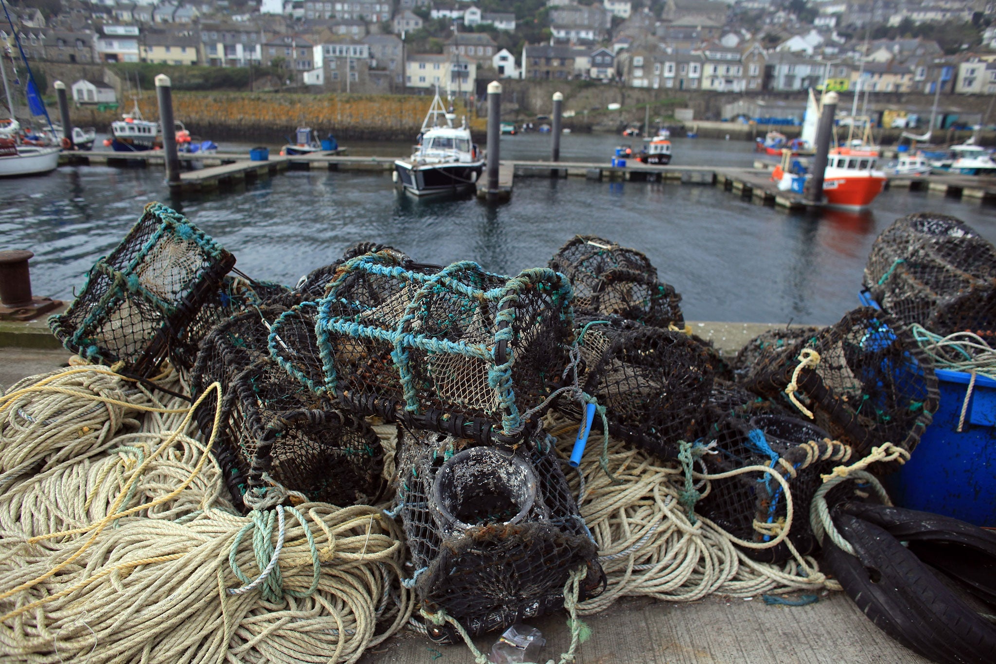 Lobster pots on the quay of Newlyn Harbour in Cornwall (Getty)