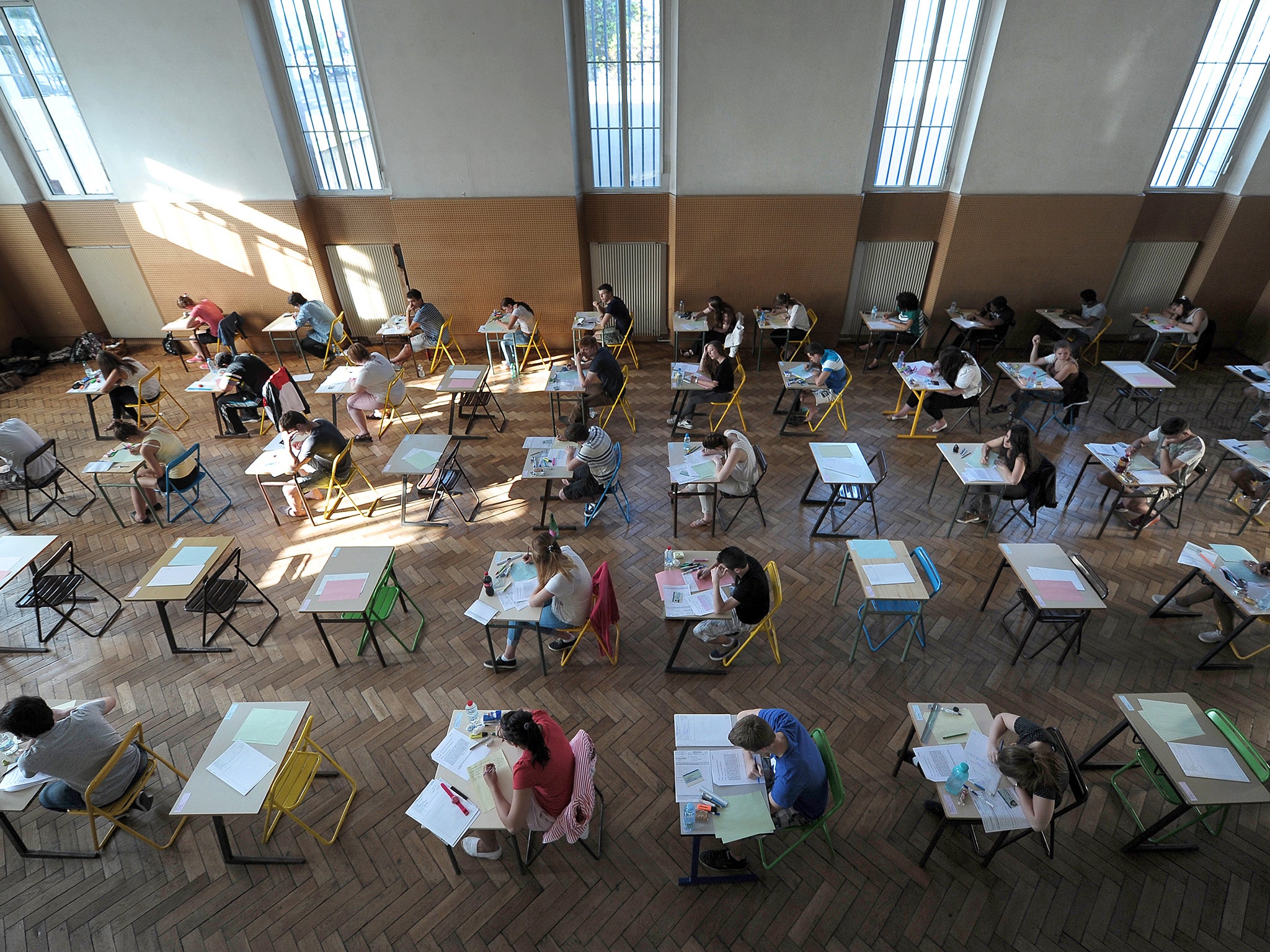 Students sit their exams in a school hall