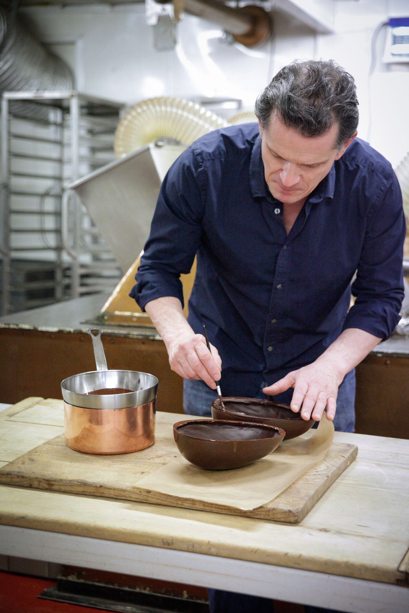 Willie brushes the egg halves with melted chocolate