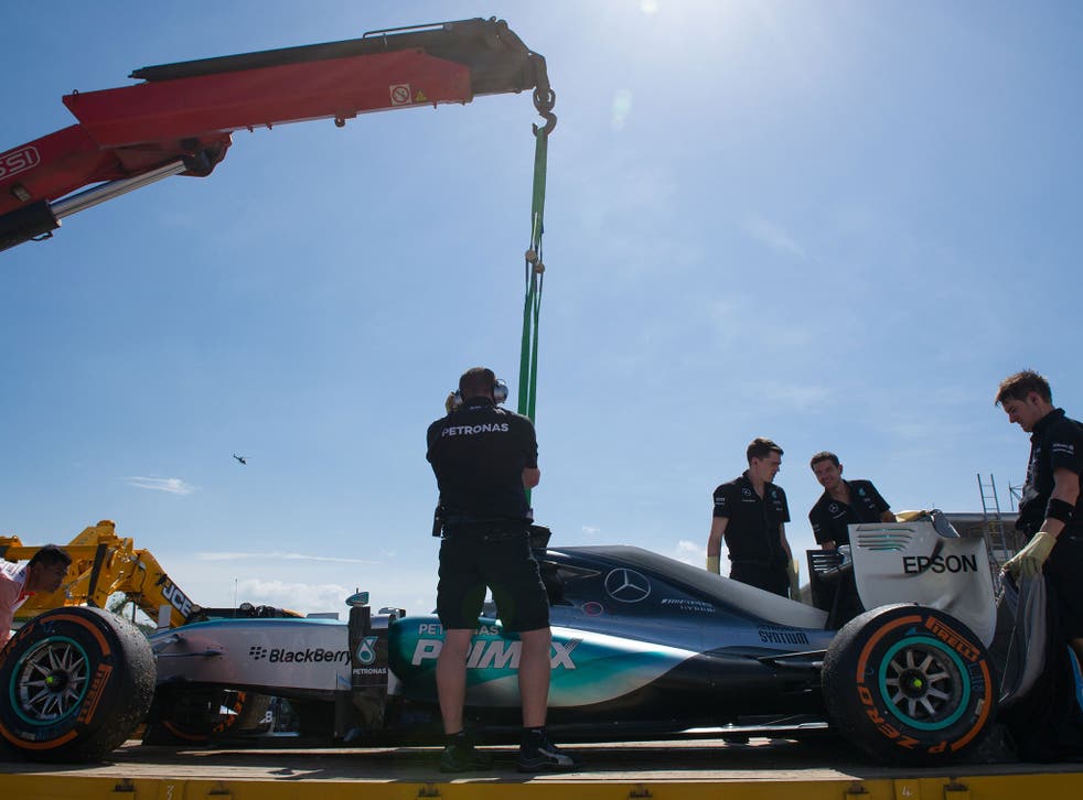 Hamilton's Mercedes is winched onto a recovery lorry