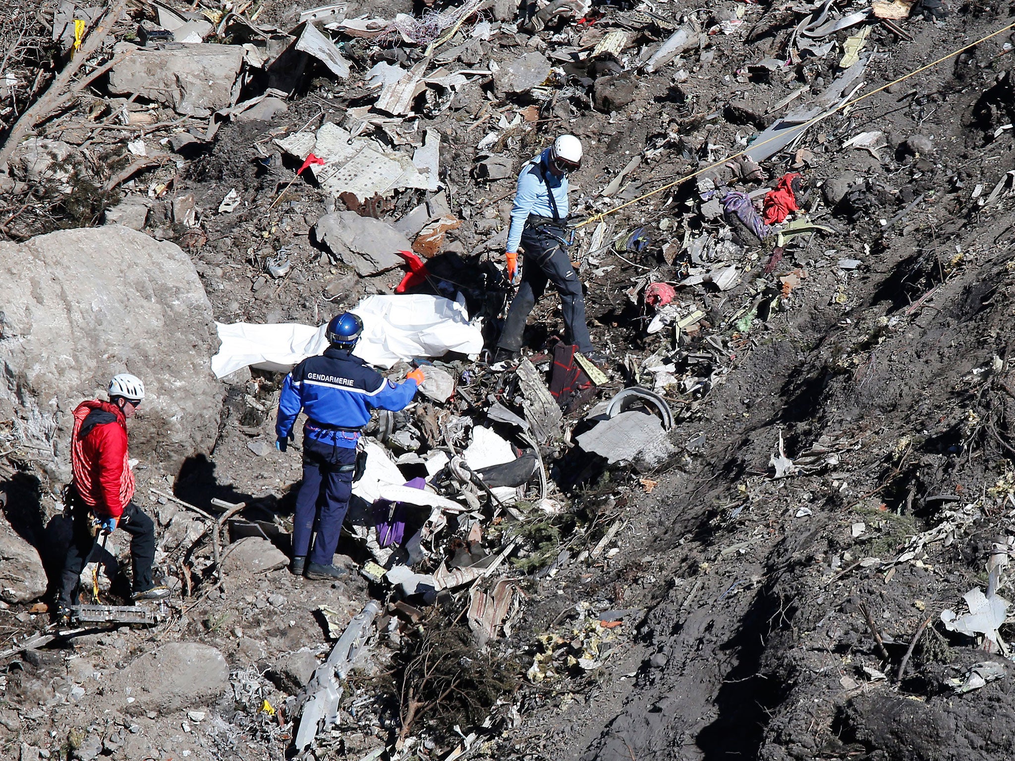 Search and rescue workers make their way through debris at the crash site of the Germanwings Airbus A320 that crashed in the French Alps, above the town of Seyne-les-Alpes, southeastern France