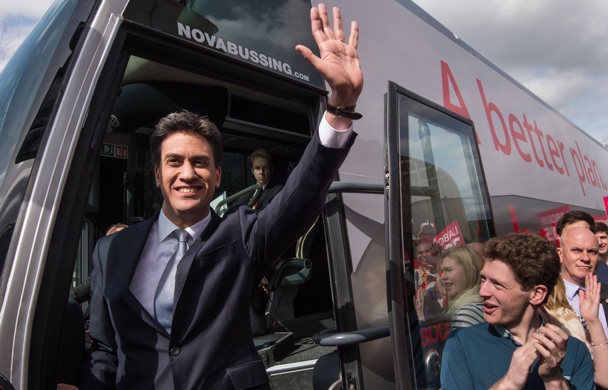 Ed Miliband waves to the crowds as he steps on to Labour's battlebus (PA)