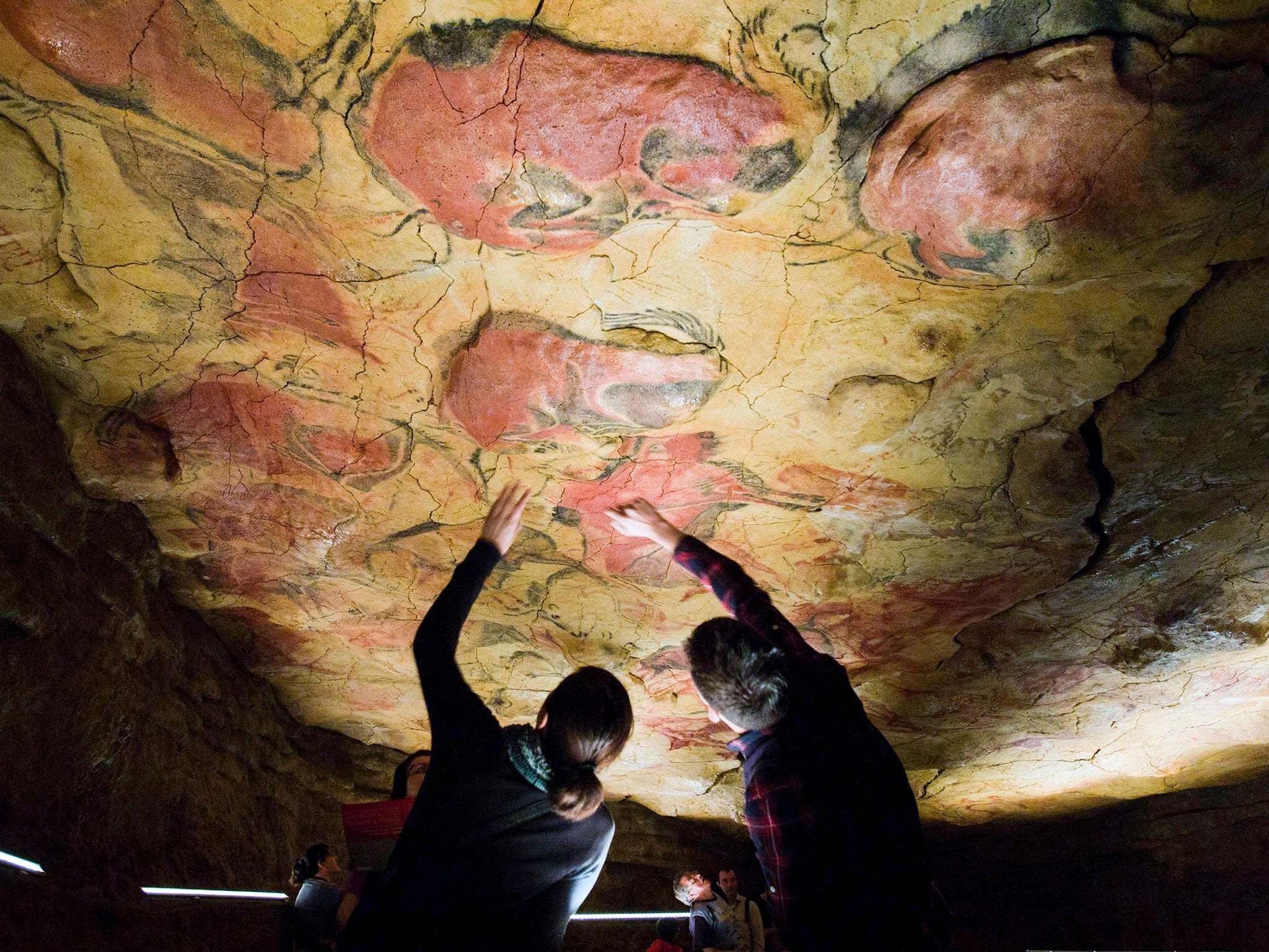 Tourists observe the drawings in the replica of the cave of Altamira near Santander, northern Spain