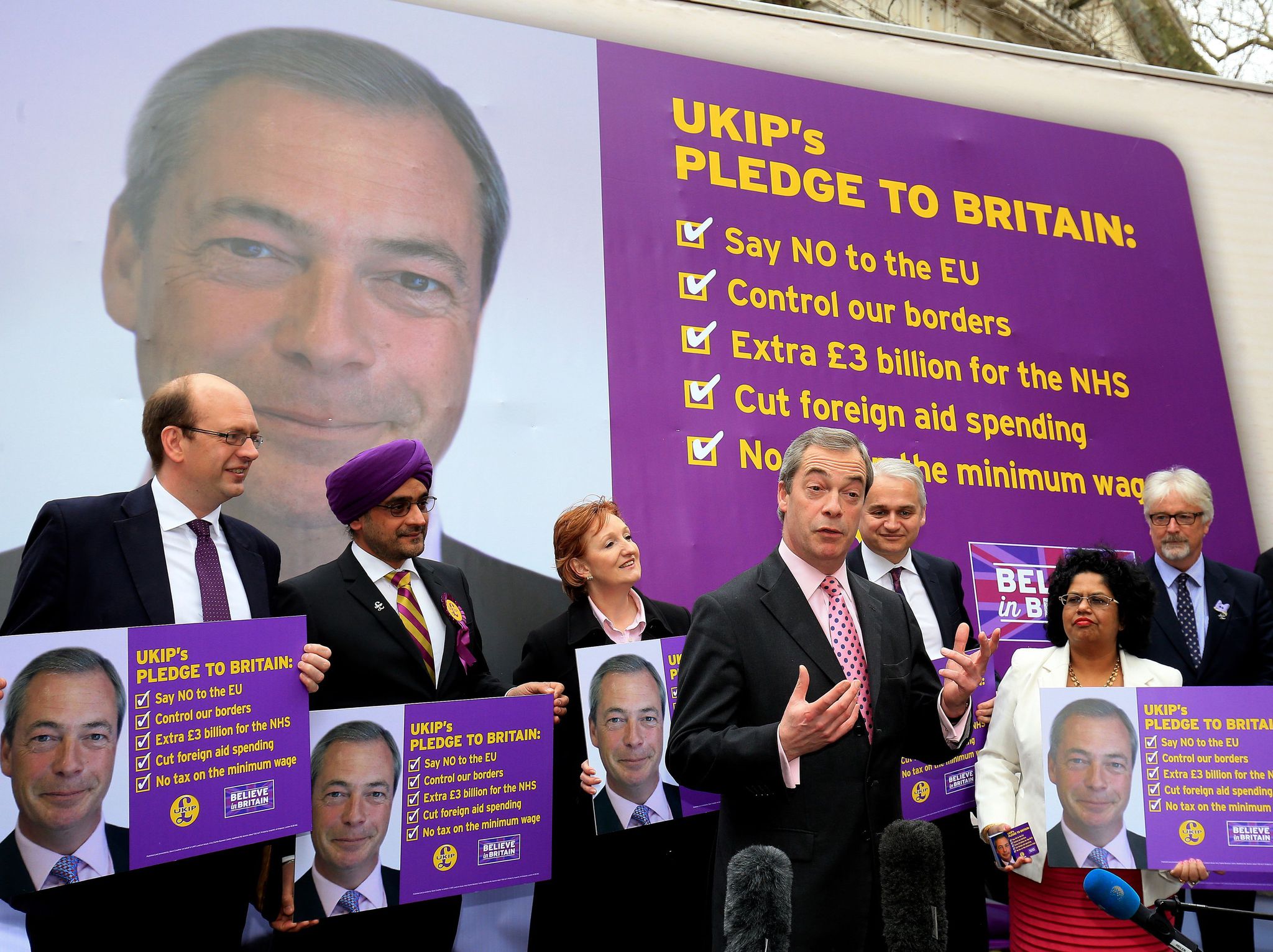 Nigel Farage is surrounded by pictures of himself as he launches Ukip's election priorities (PA)
