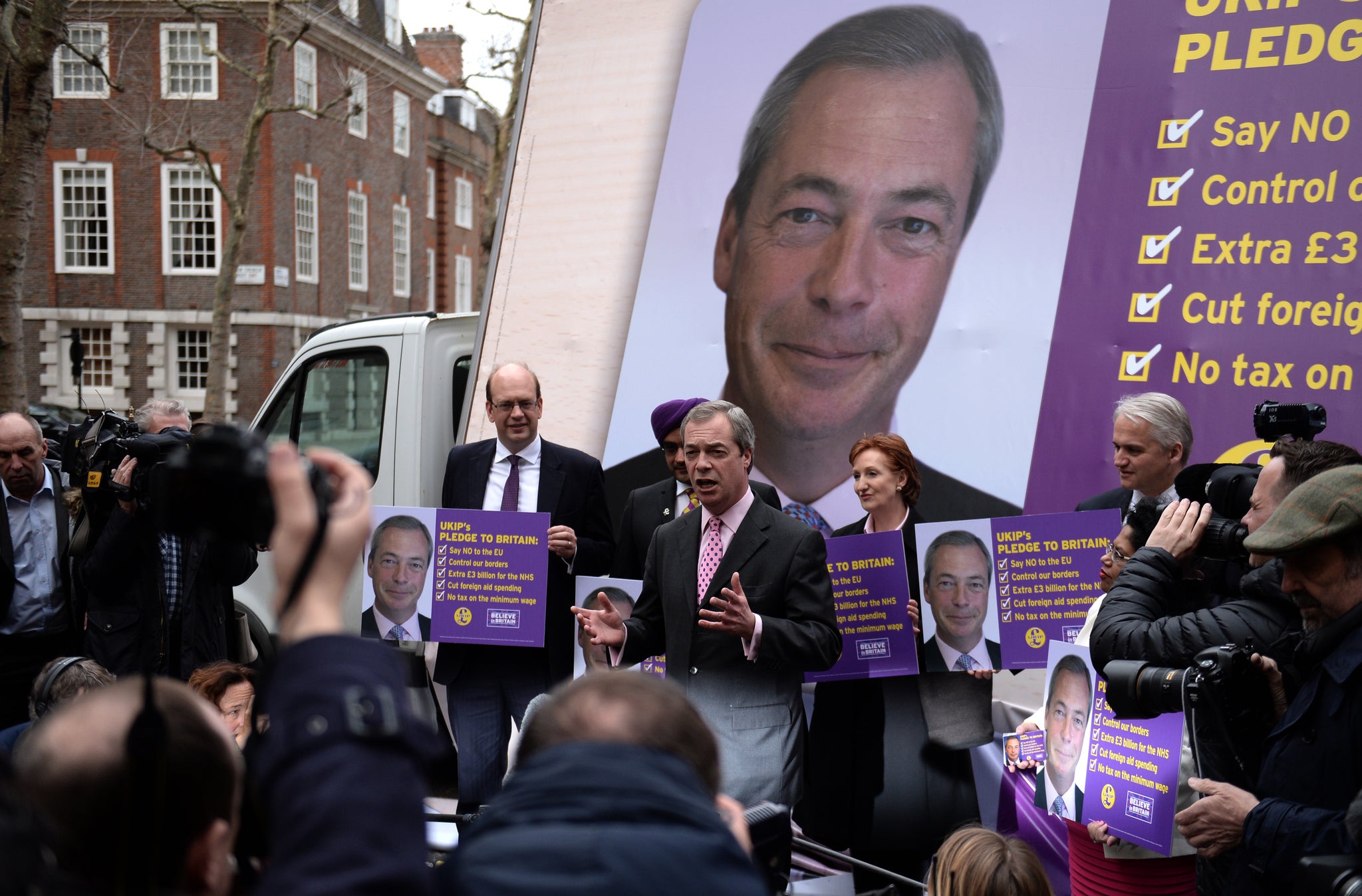 Ukip's stars surround their leader with pictures of his face (PA)