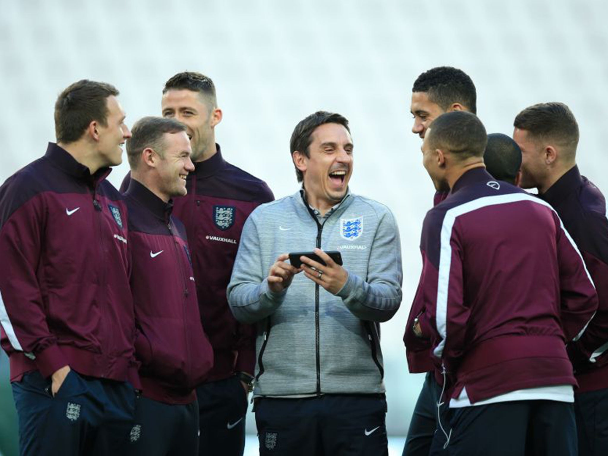 Coach Gary Neville shares a joke with members of the England squad