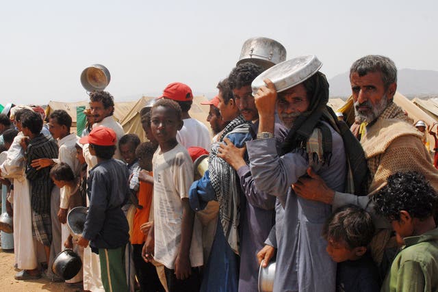 Yemeni refugees queue to get food aid at the Marzaq internally displaced people's camp in Harad in the northwestern province of Hajjah  