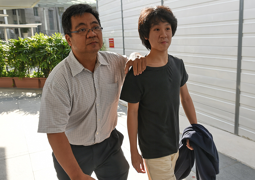 Amos Yee arrives with his father at the State courts in Singapore on March 31