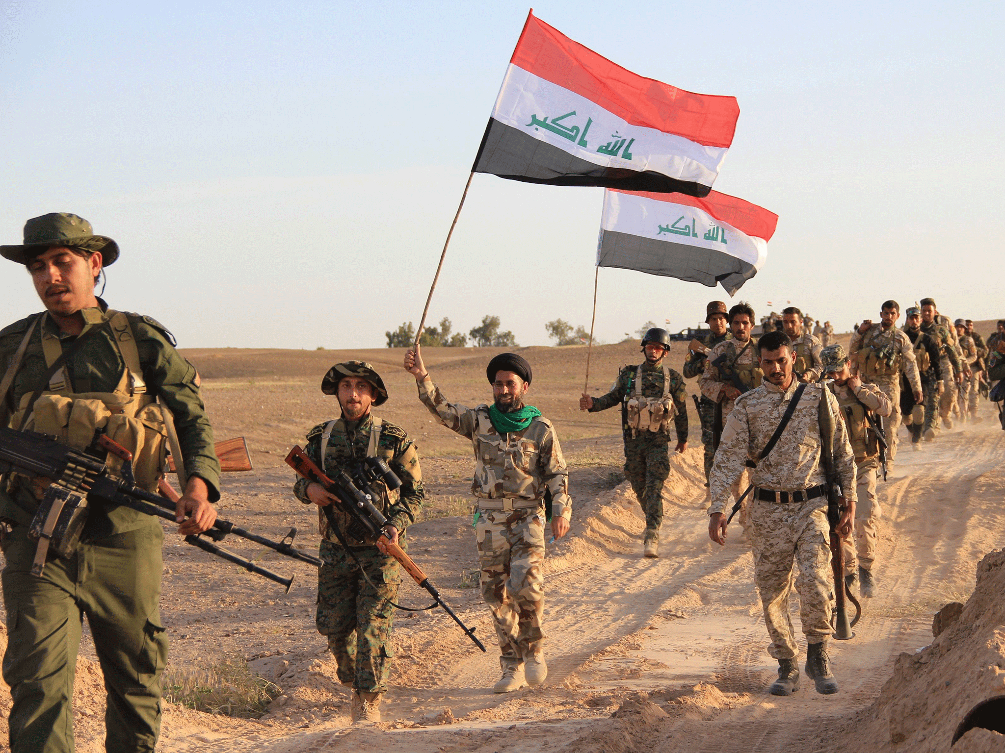 Iraqi soldiers and members of Iraqi Shia militia carry the Iraqi flag during fighting with Isis militants, in Tikrit, Iraq, 31 March 2015