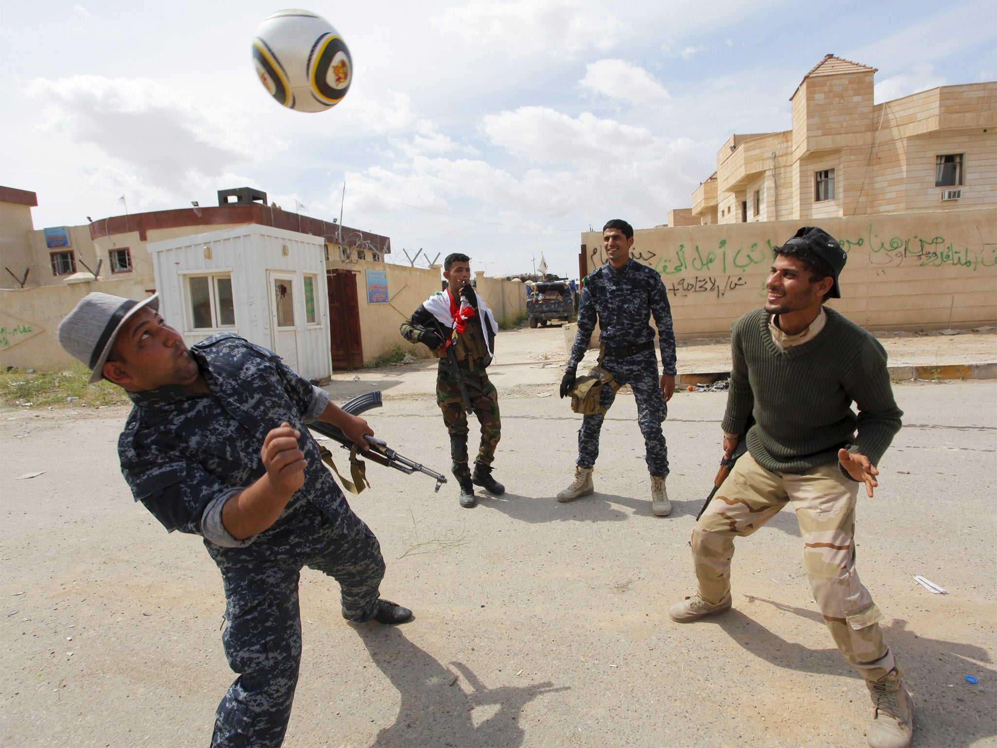 Iraqi security forces playing football in Tikrit after their country declared a 'magnificent victory' in the city