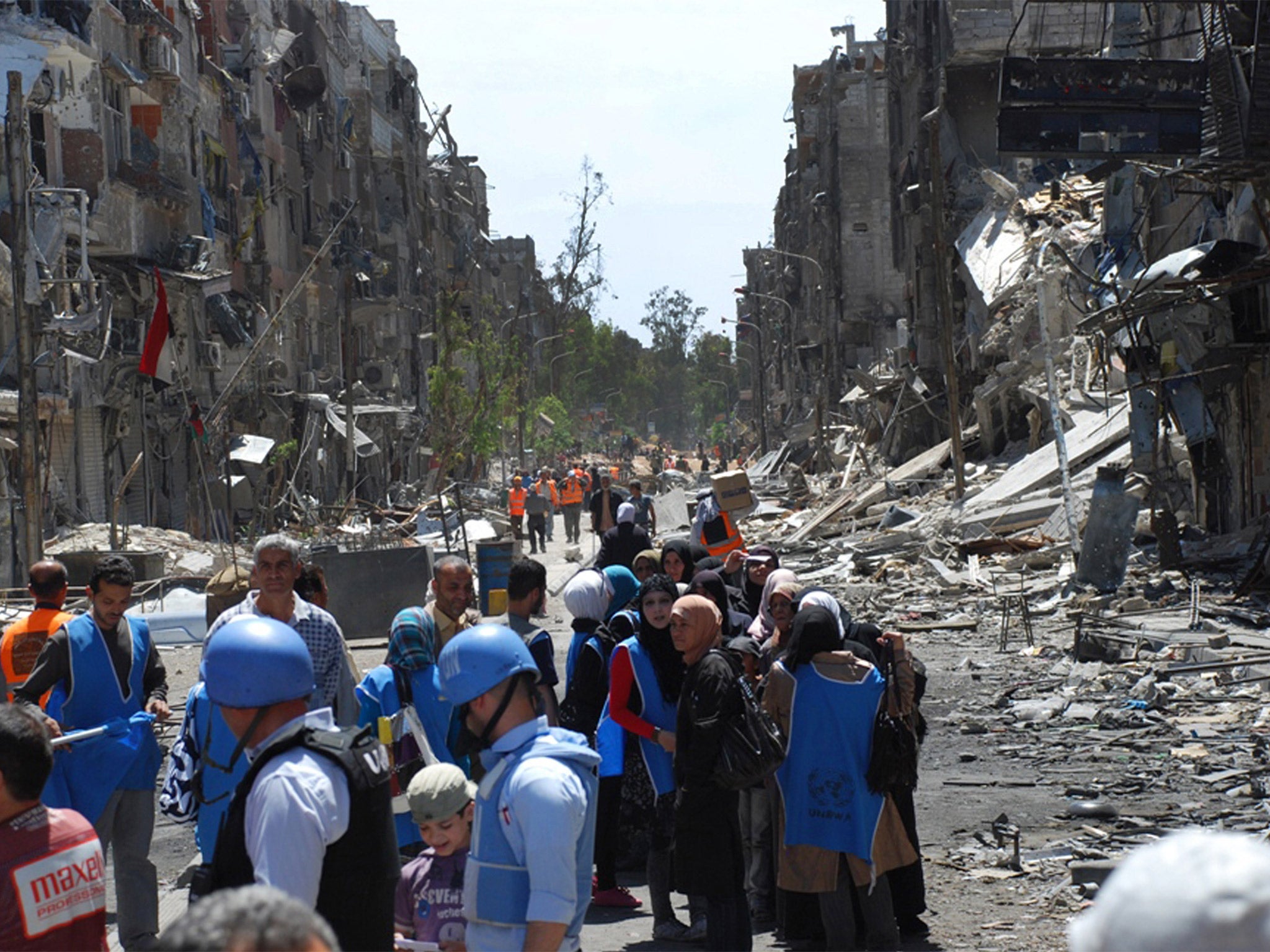UN relief workers with local residents of the besieged Palestinian camp of Yarmouk, pictured last year