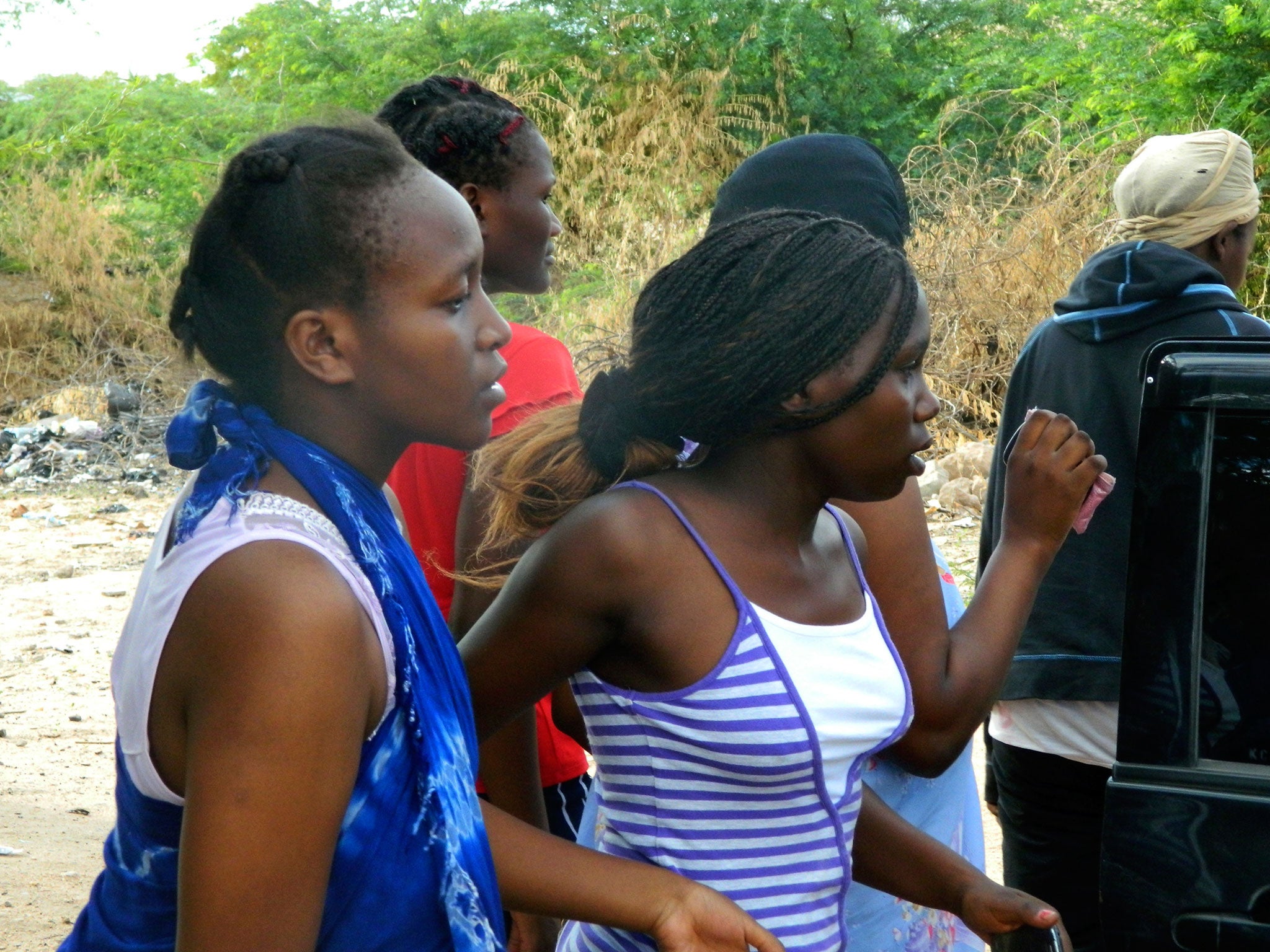 Students get out of a house where they seek refuge after fleeing from an attack by gunmen in Garissa