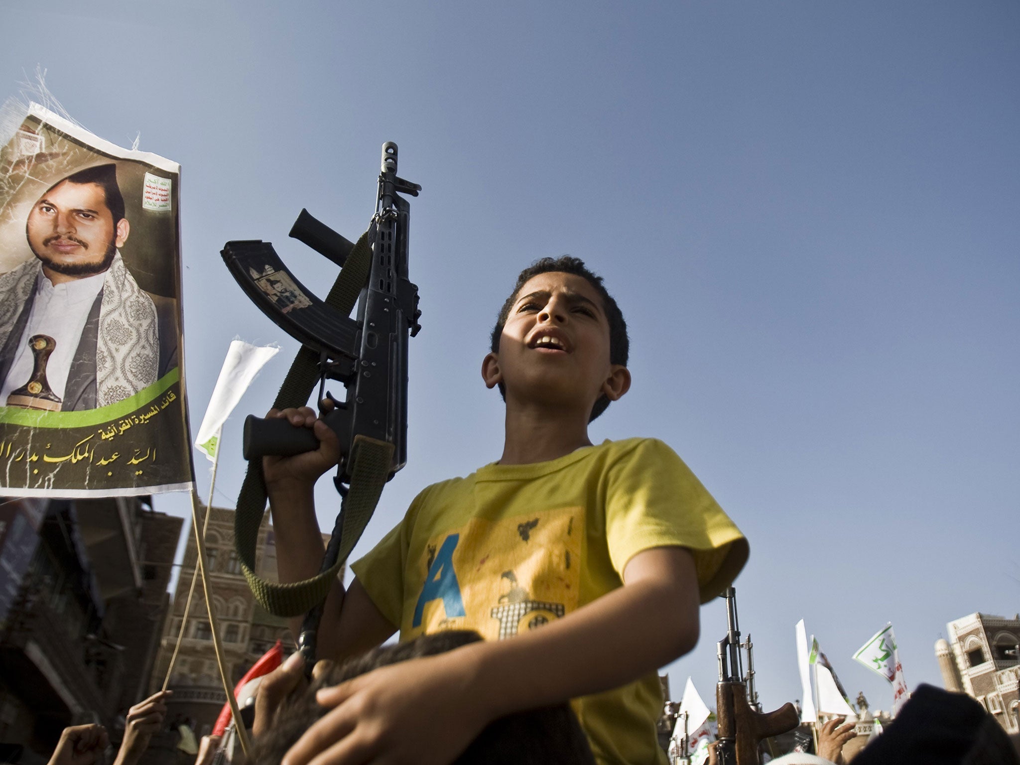 A boy holds a weapon while Shiite rebels known as Houthis protest against Saudi-led airstrikes, during a rally in Sanaa, Yemen, Wednesday, April 1, 2015