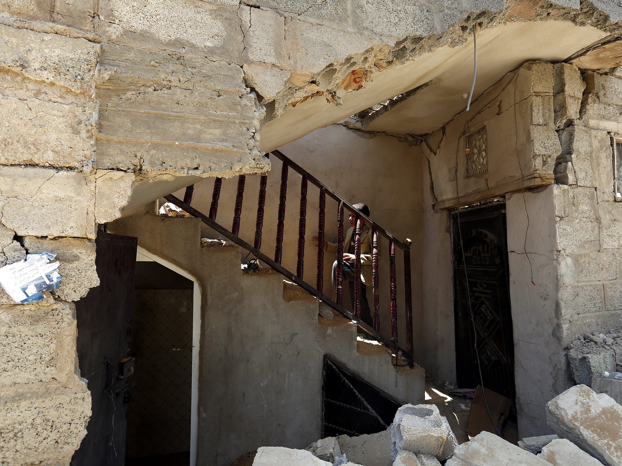 A Yemeni boy inspects his family's house, which was destroyed by an airstrike allegedly carried out by a Saudi-led coalition against a Houthi rebels in Sanaía, Yemen