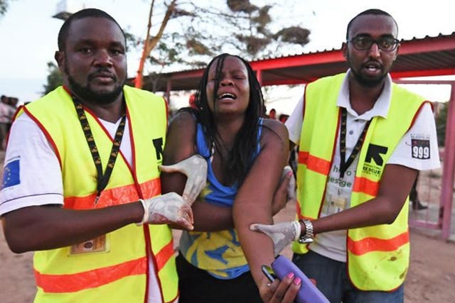 Paramedics help a woman who was injured during an attack by Somalia's Al-Qaeda-linked Shebab gunmen on the Moi University campus in Garissa on April 2, 2015. At least 70 students were massacred when Somalia's Shebab Islamist group attacked a Kenyan univer