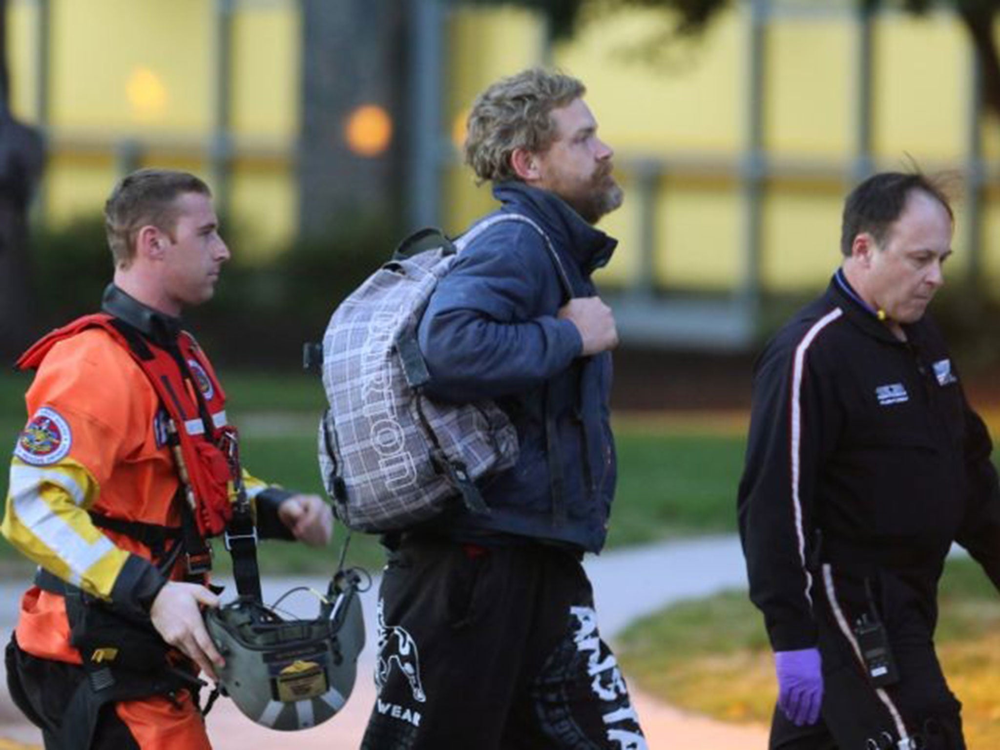 Louis Jordan, centre, walks from the Coast Guard helicopter to the Sentara Norfolk General Hospital in Norfolk, after being rescued on 2 April