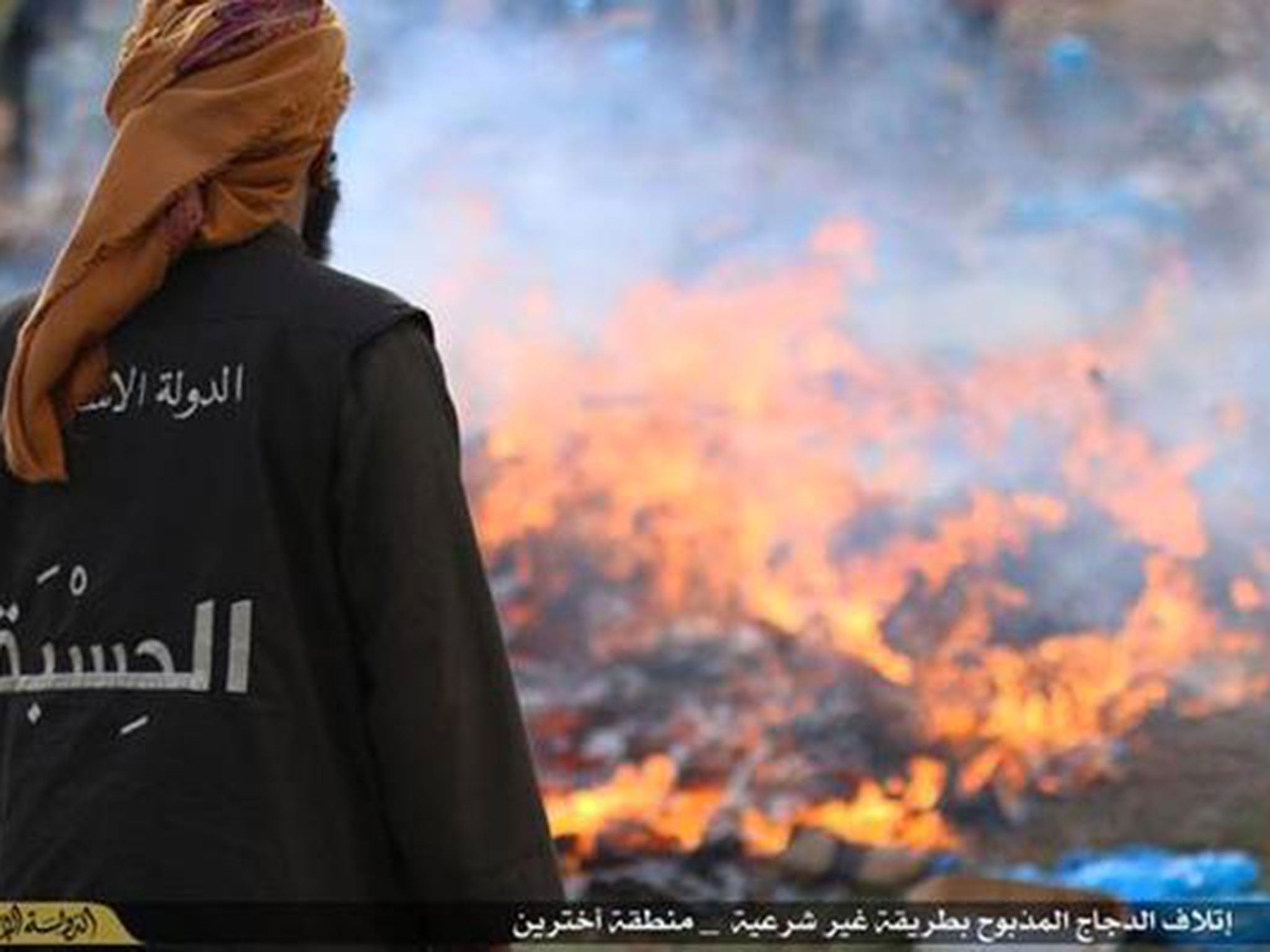 A man stands next to the burning pyre