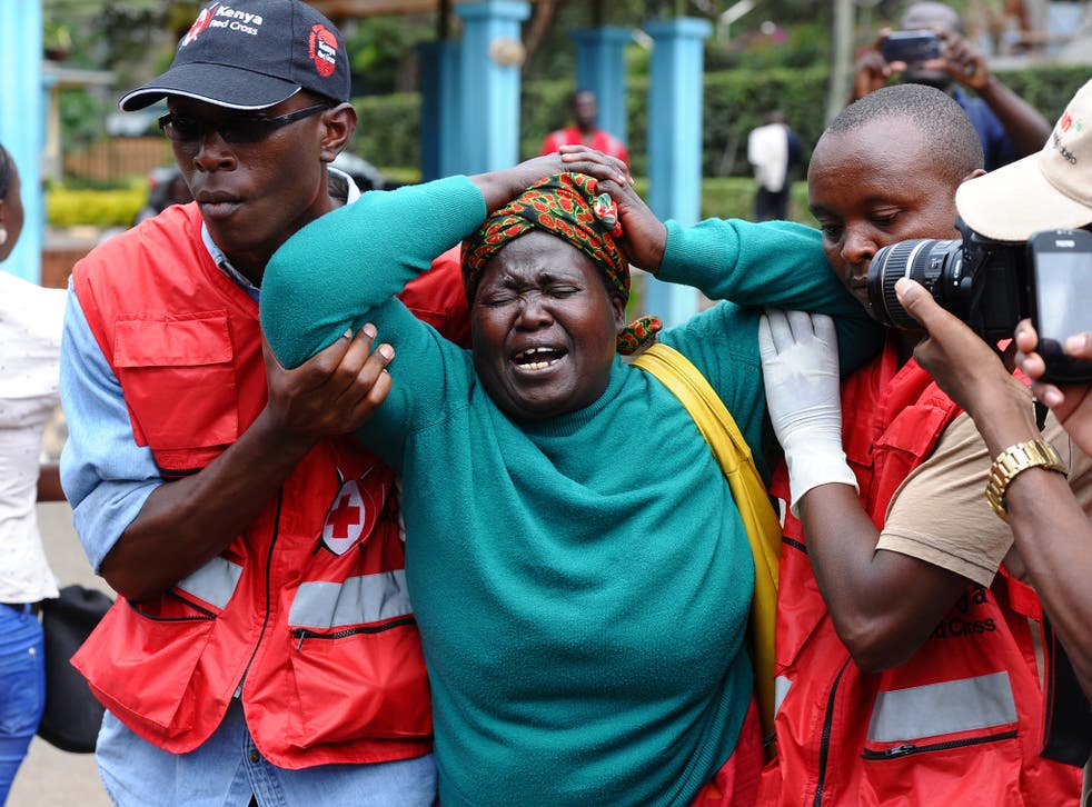 A woman is helped by Red Cross staff after viewing a relative’s body