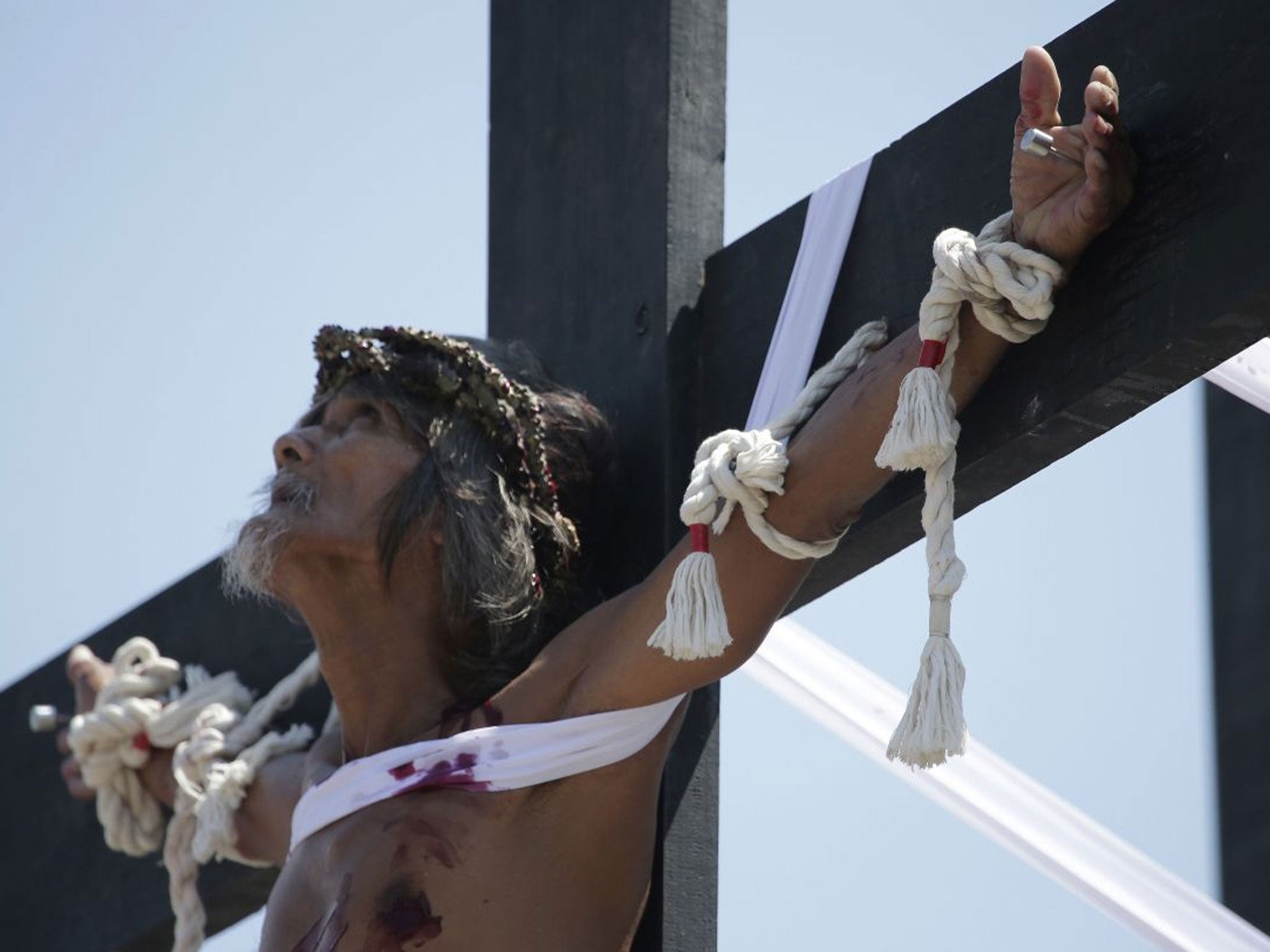 A Filipino penitent looks up as he is nailed to a wooden cross during Good Friday in Pampanga province, northern Philippines.