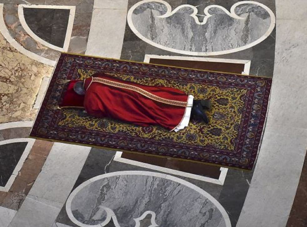Pope Francis lies on the floor to pray on Good Friday