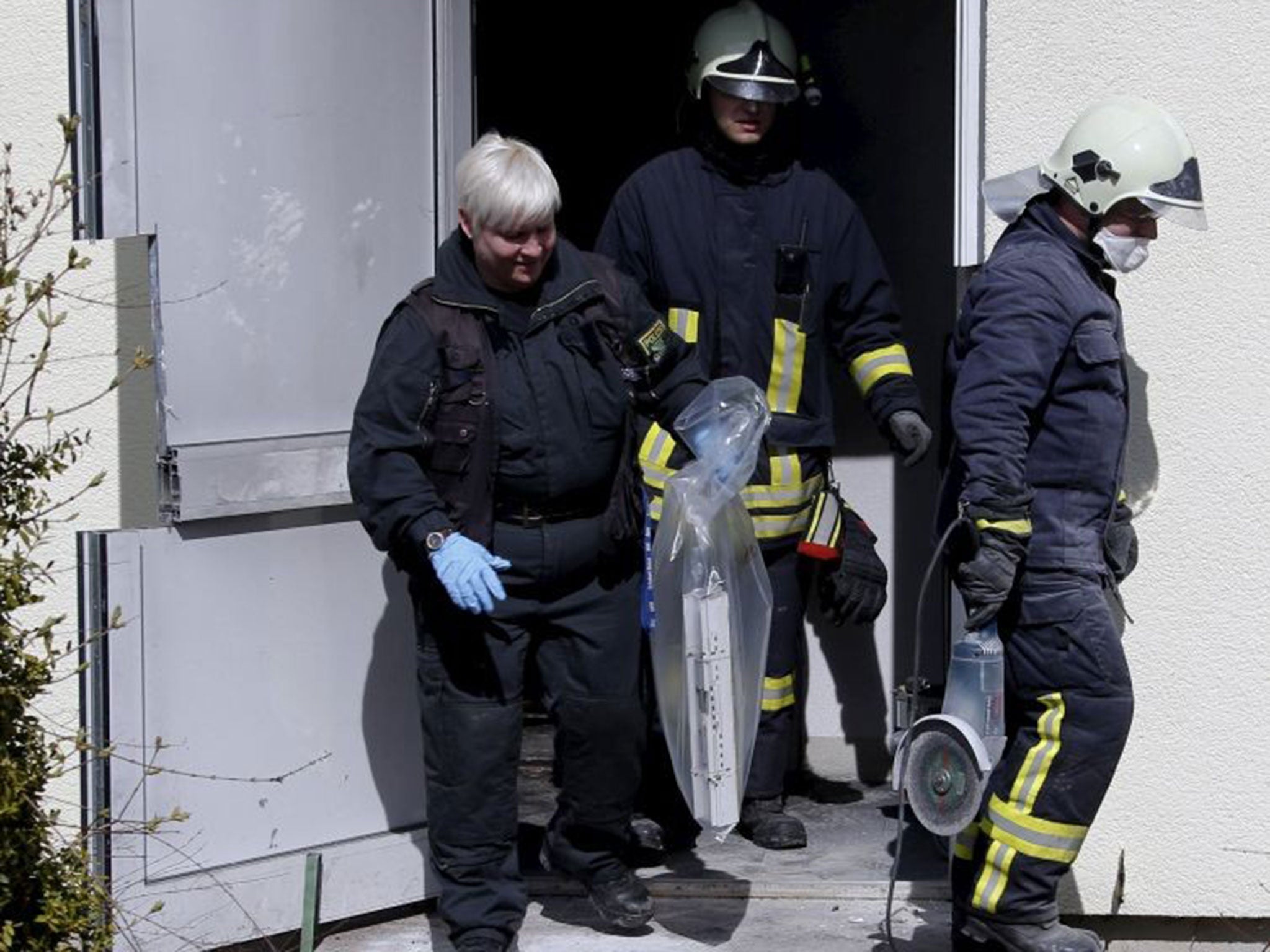Police investigators and firefighters gathering evidence in the building
