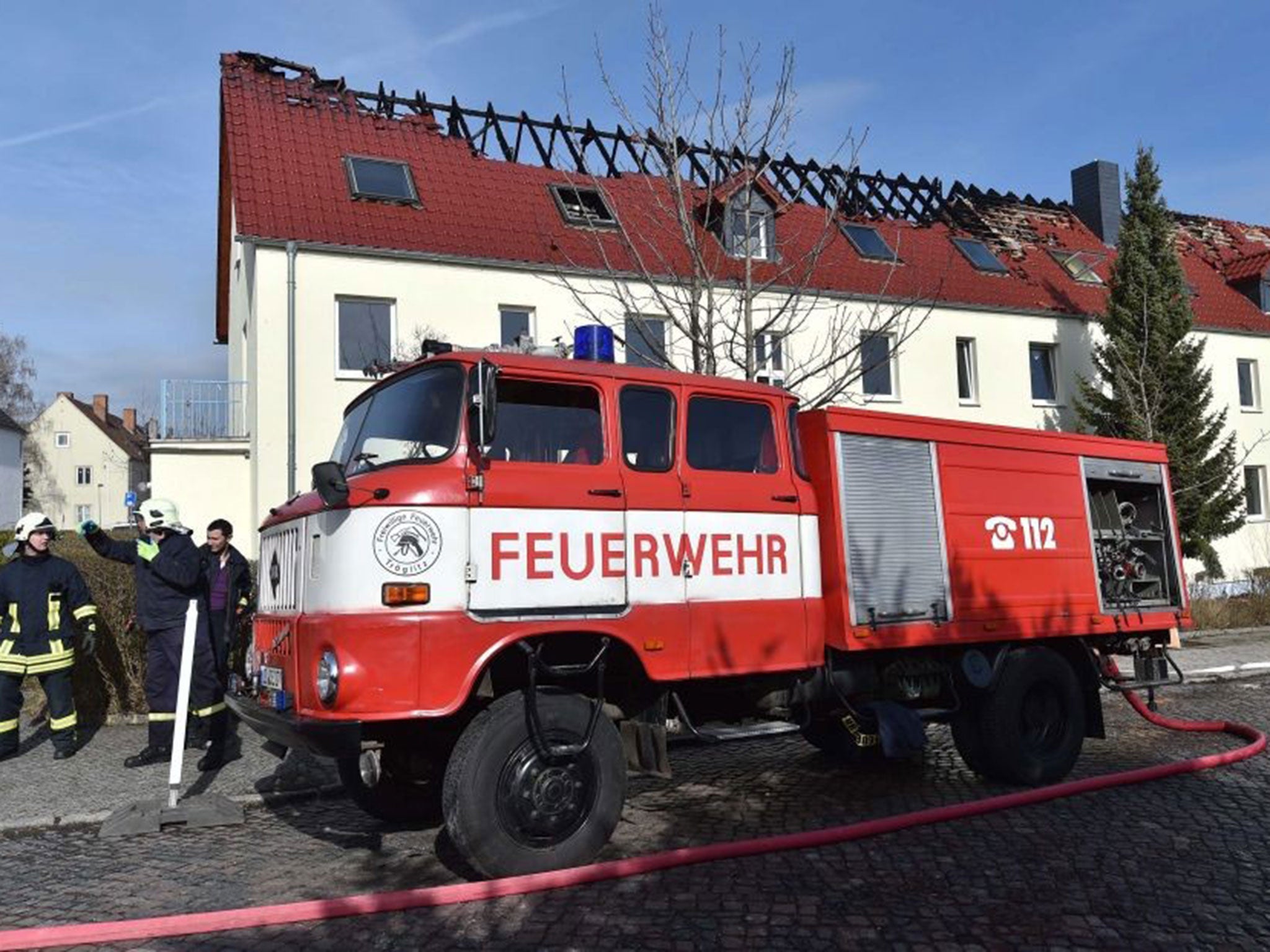 Emergency services and police at the scene of a burnt-out building that was to be used to house asylum seekers