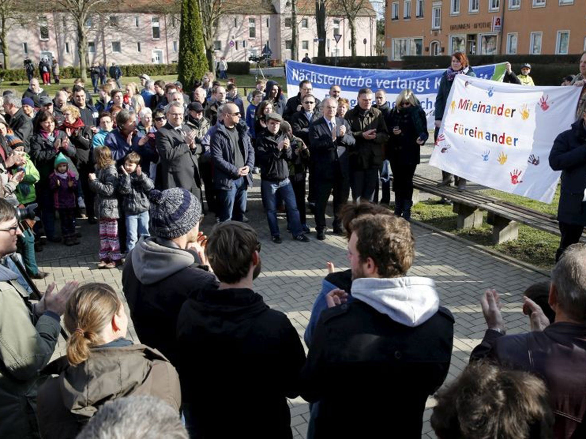Residents hold a banner reading "Together for each other" during an anti-racism rally following the fire
