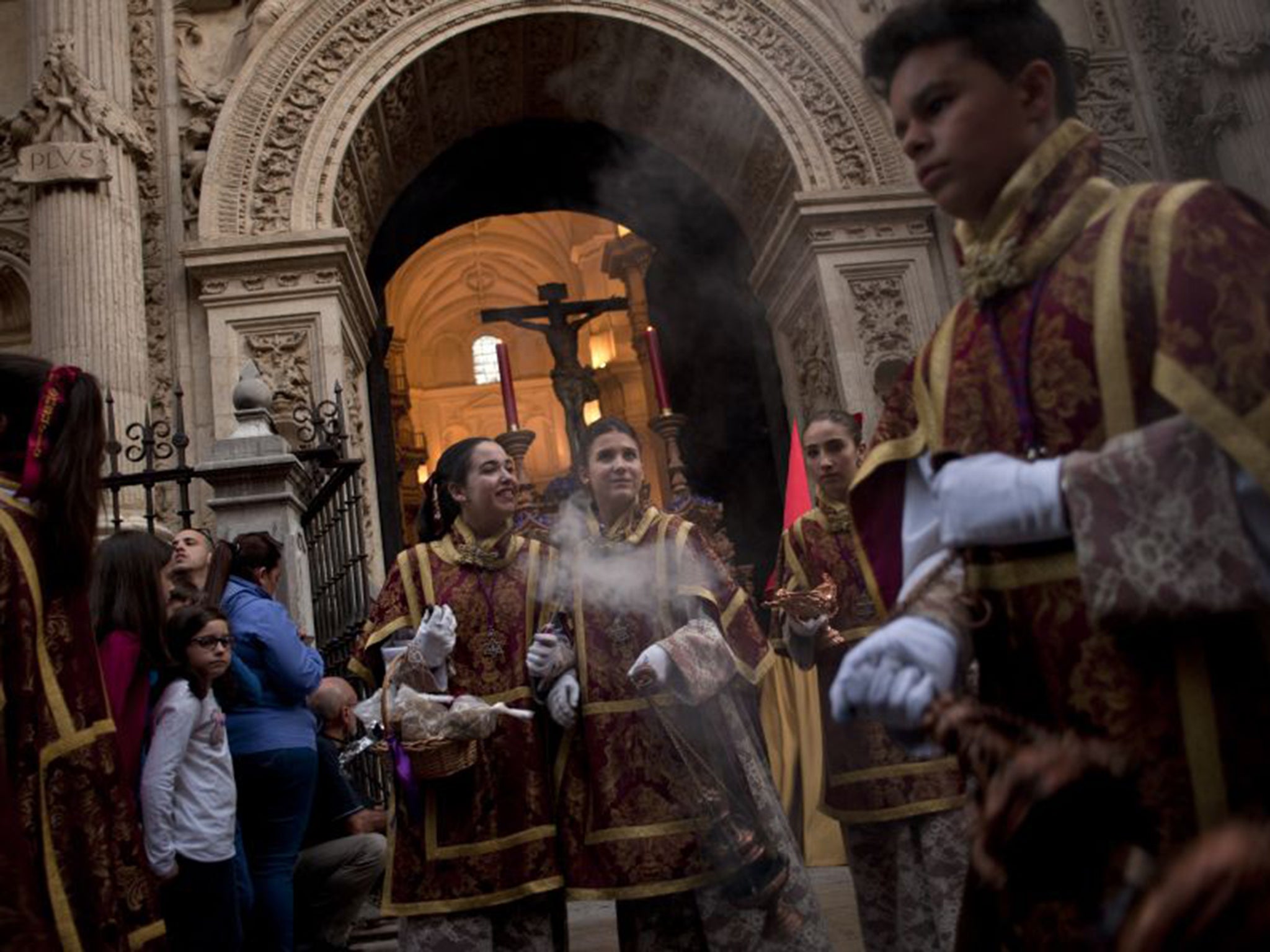 Servers swing censers during a Holy Week procession in Granada that draws huge crowds