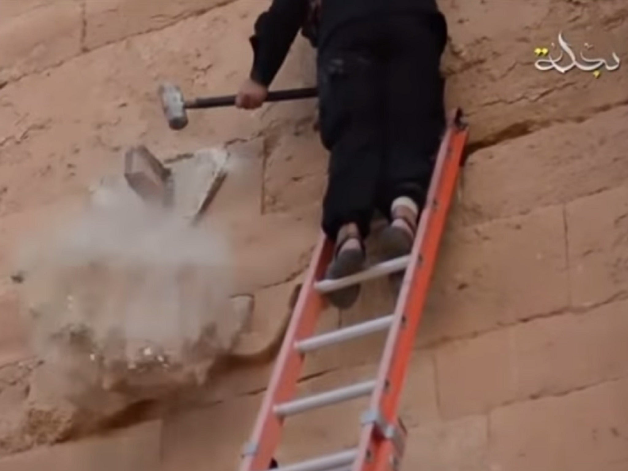 The wall sculpture falls to the floor after being hit by a sledgehammer