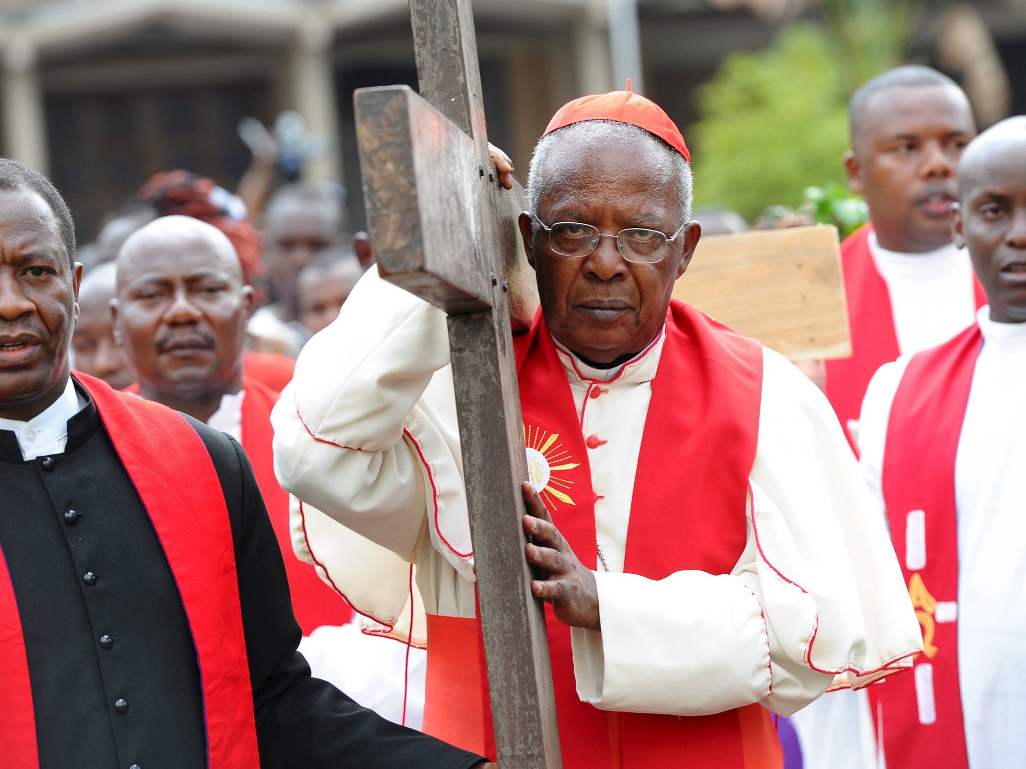 Cardinal John Njue carries a cross during a Good Friday procession outside the Holy Family Basilica Catholic Church in Kenya's capital Nairobi