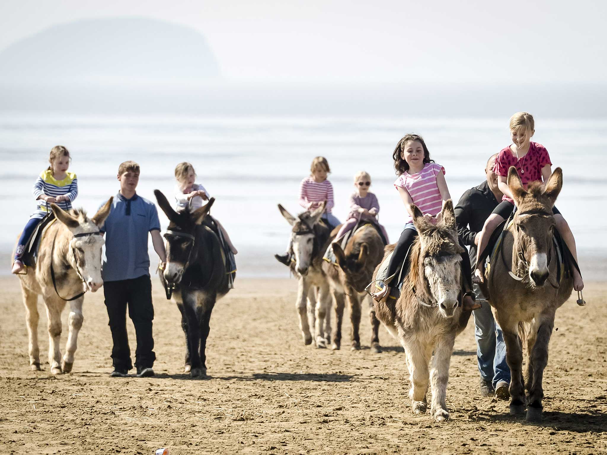 Children ride donkeys at Weston-Super-Mare beach, in Somerset, on Bank Holiday Monday yesterday