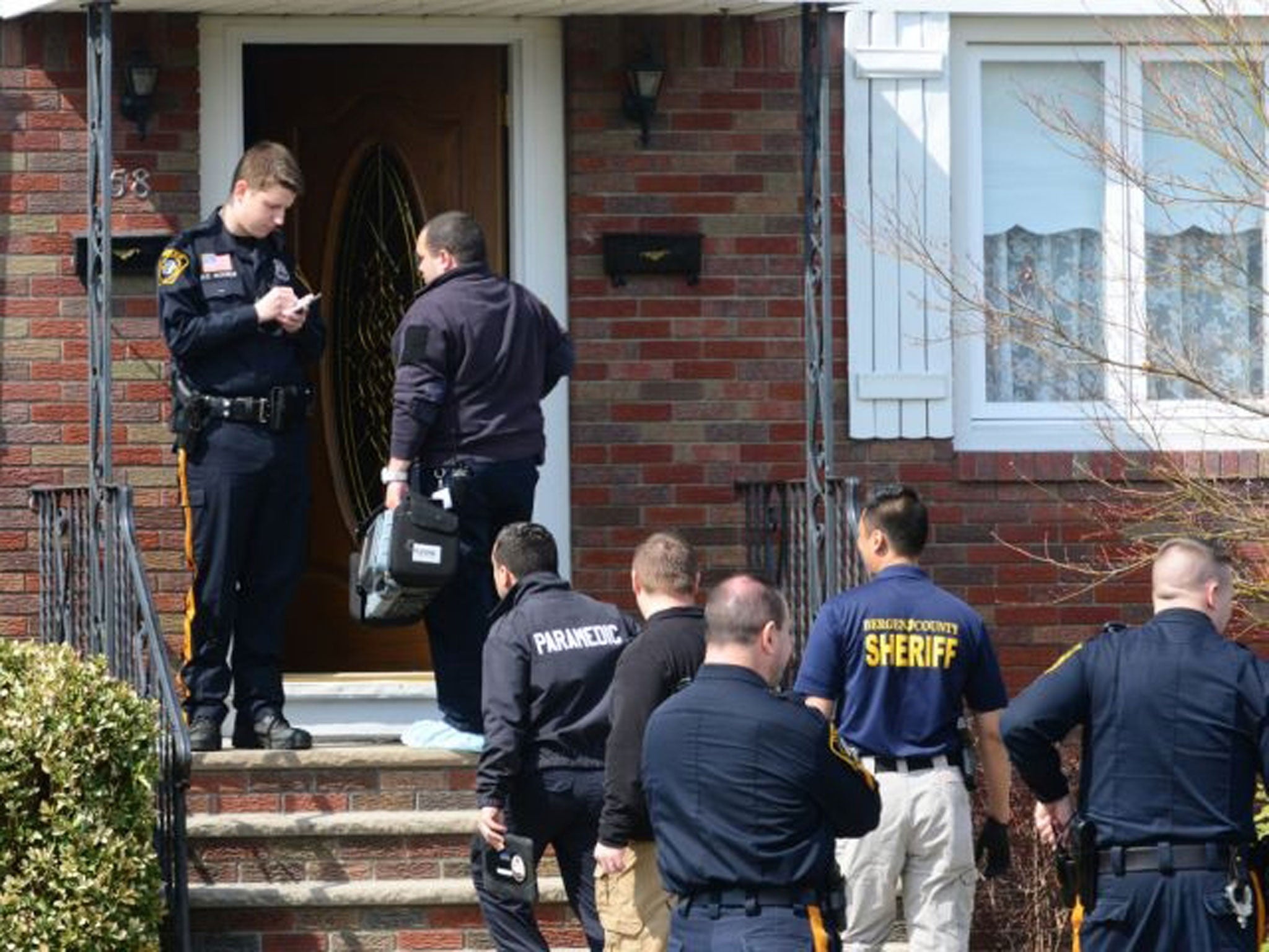 Authorities arrive at a home where the bodies of an elderly couple were found Monday, April 6, 2015, in Elmwood Park, N.J. Prosecutors say a 100-year-old man apparently killed his wife with an ax as she slept in their home, then killed himself in the bath