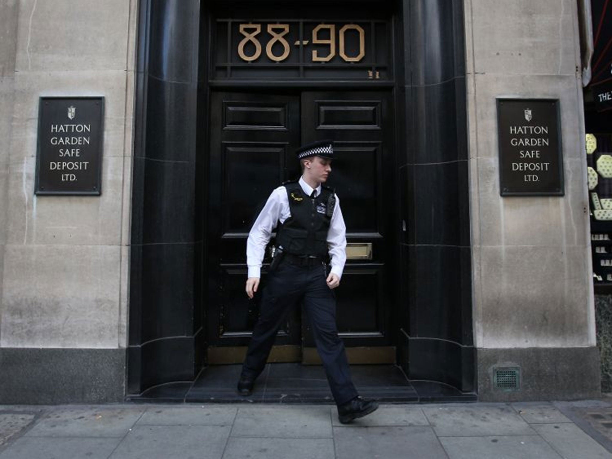 A policeman emerges from a Hatton Garden safe deposit, where burglars broke into safety deposit boxes.