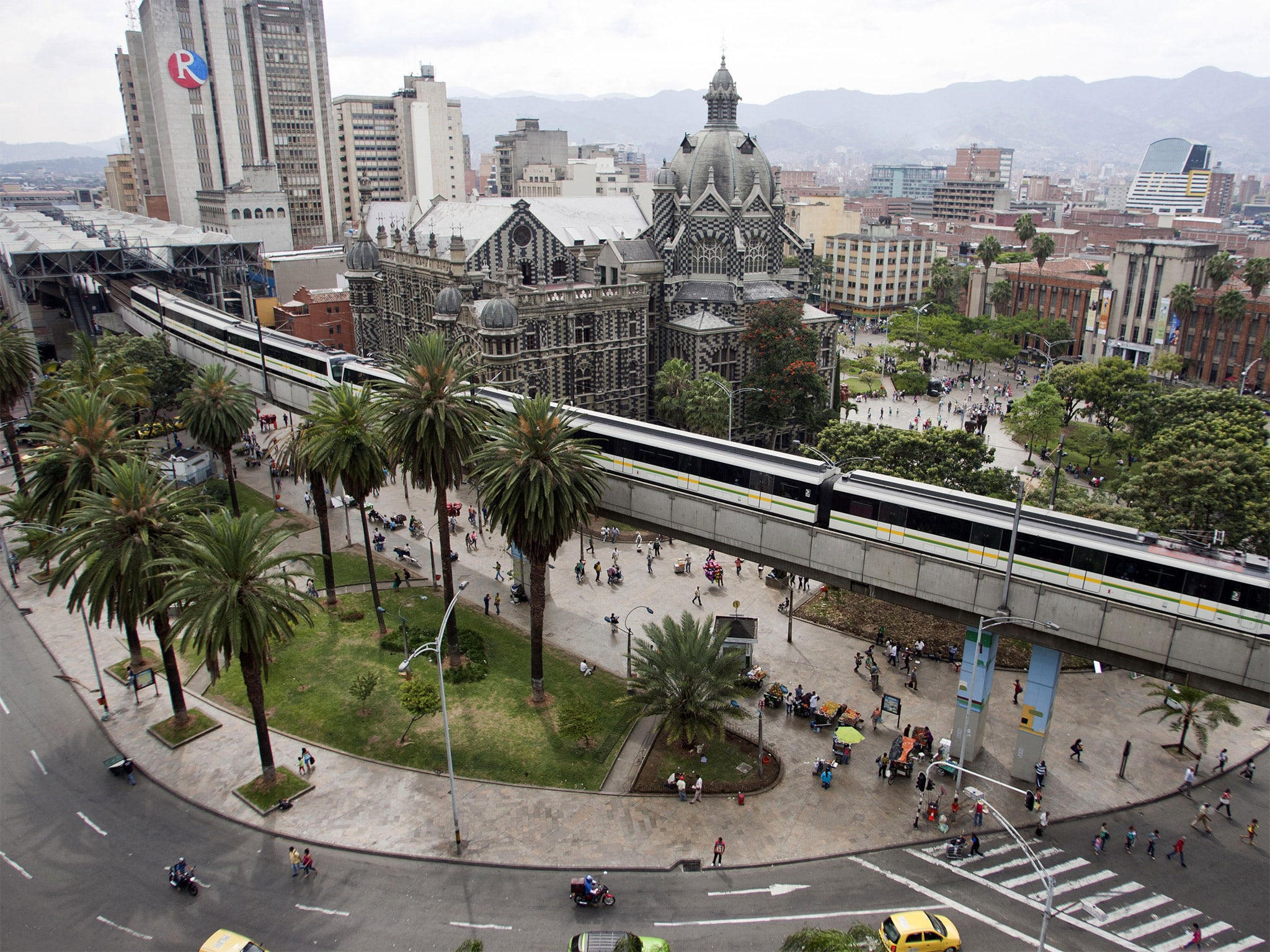 The metro line sweeps through Plaza Botero and past the Palace of Culture