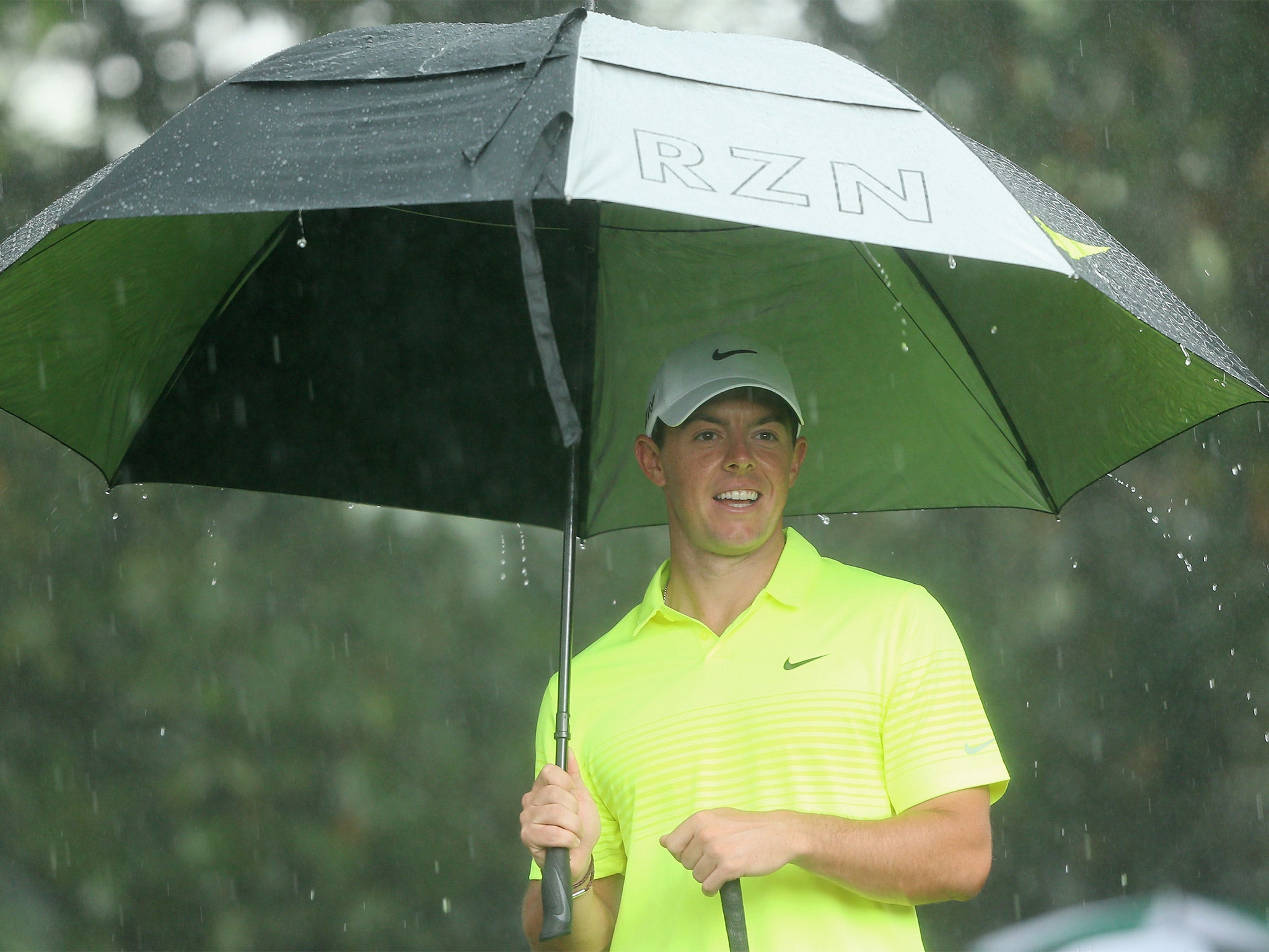 Rory McIlroy takes shelter as the rain beats down during practice at Augusta National on Tuesday