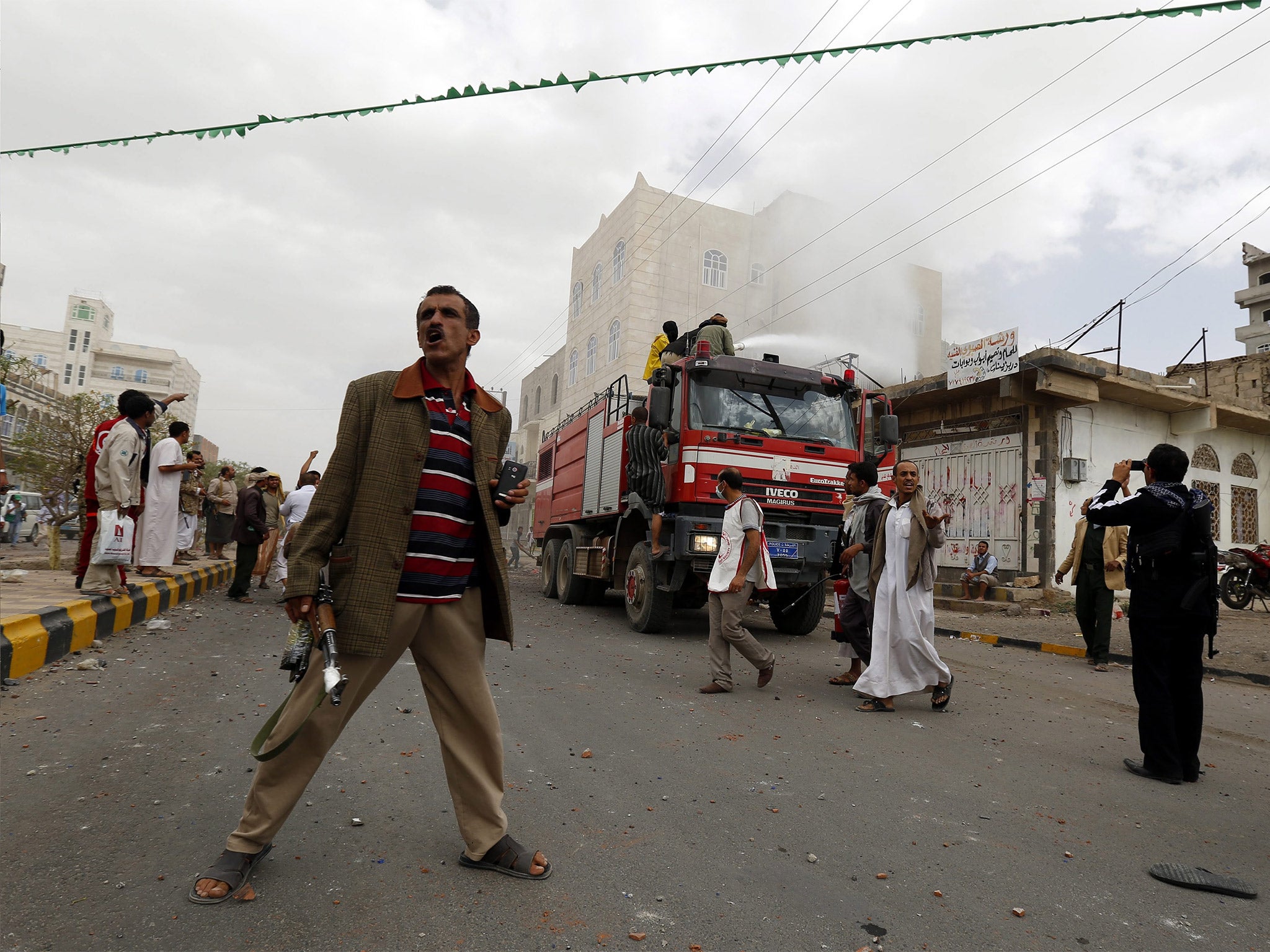 Yemenis gather at the scene of an air strike targeted at a Houthi area in Sanaa