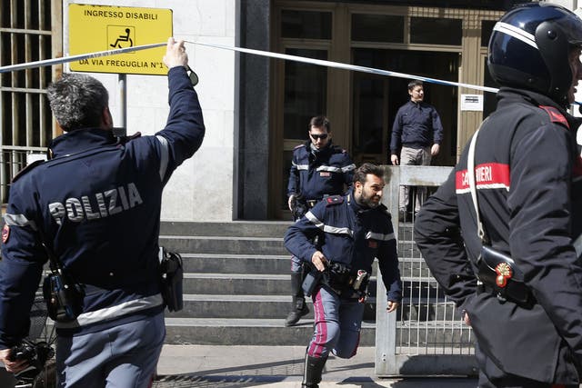 Policemen run out of the tribunal building in Milan, Italy, after a shooting was reported inside a courtroom 