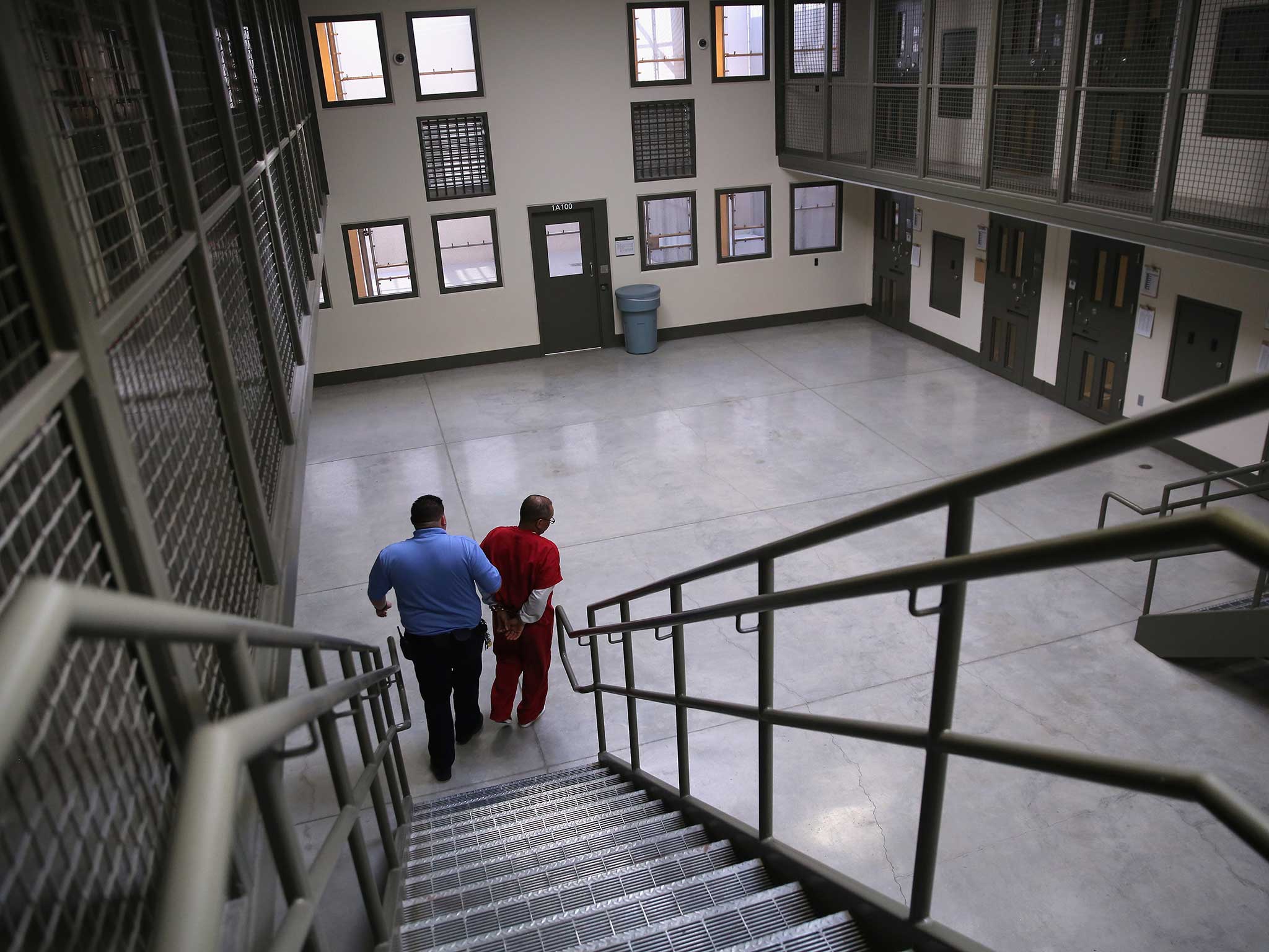 A prisoner is walked by a guard downstairs in one of California's state institutions