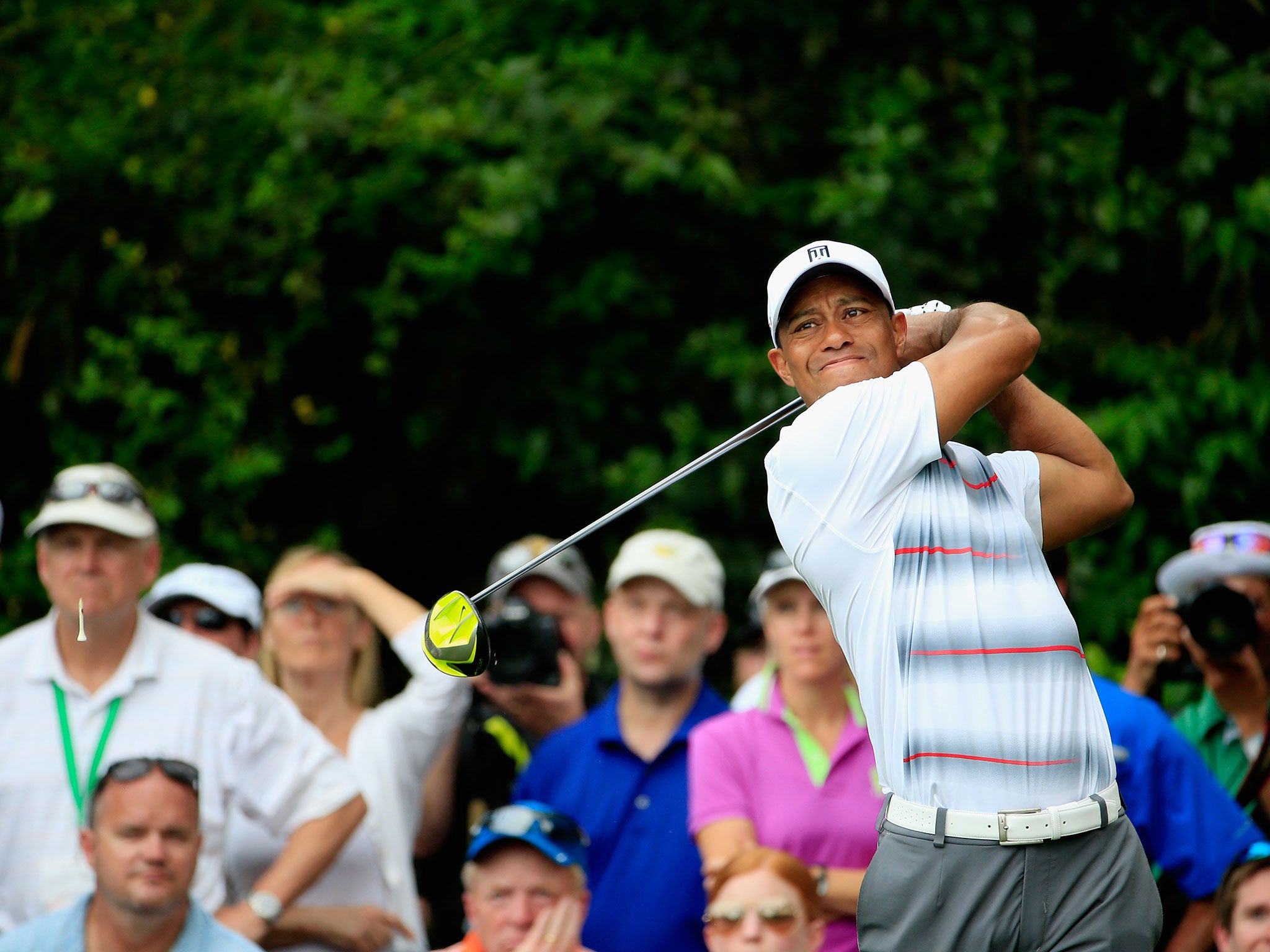 Tiger Woods grimaces as he shanks his tee shot